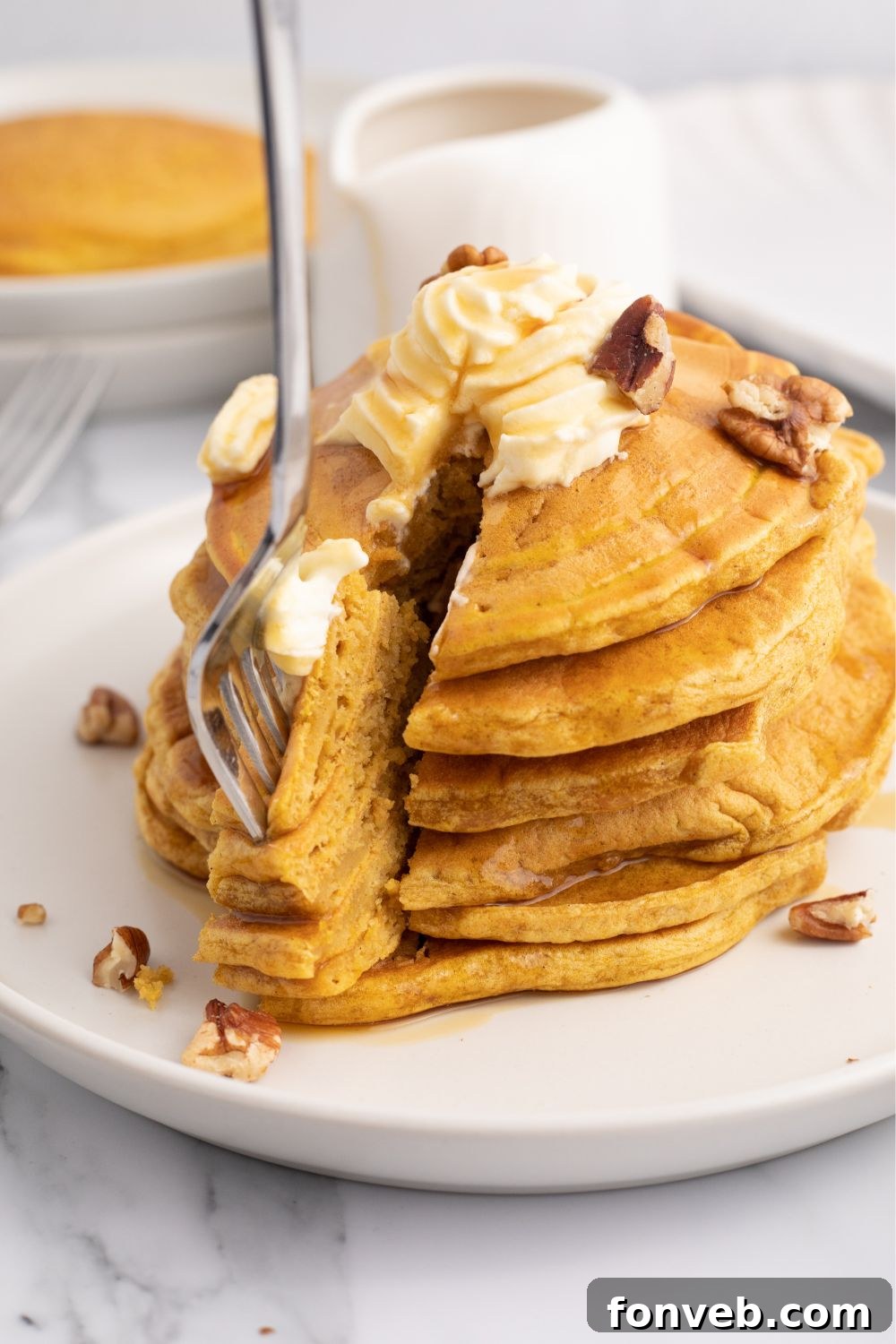 slice and pancakes stacked on plate