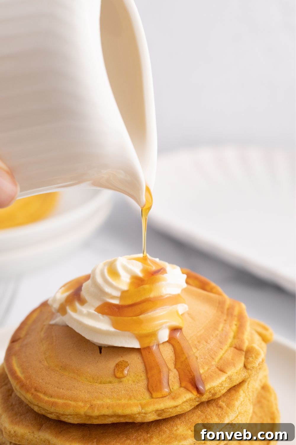 syrup being poured on top of pancakes