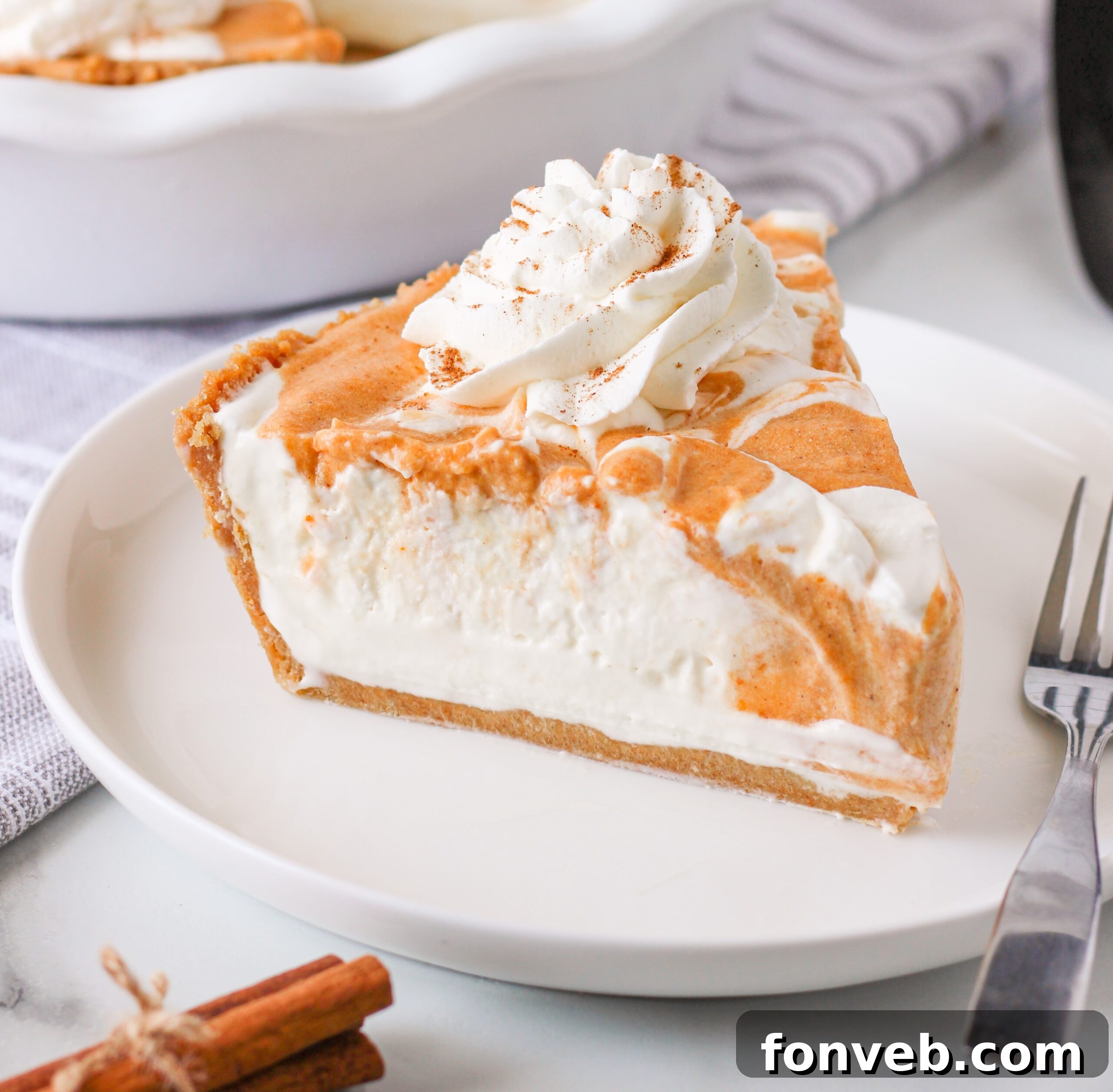 Spiced Pumpkin Ice Cream Pie 26 Pumpkin Ice Cream Pie on a white plate topped with whipped cream
