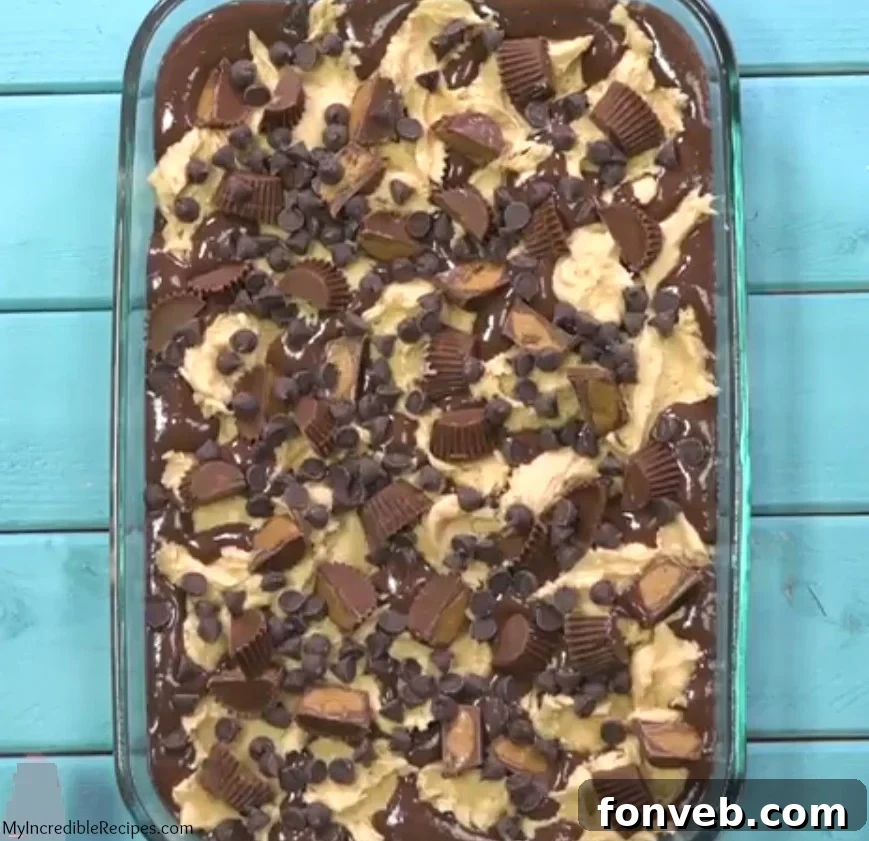 A generous slice of Peanut Butter Earthquake Cake, showing layers of chocolate cake, peanut butter, and cream cheese swirl