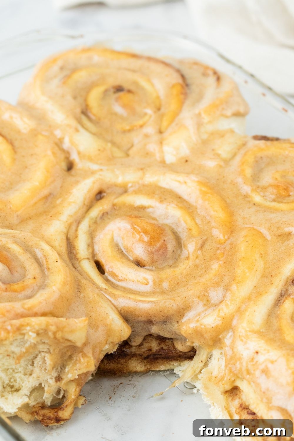 pumpkin cinnamon roll with a roll missing from the pan
