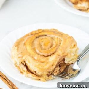 Pumpkin Cinnamon Roll on plate with a fork on the side