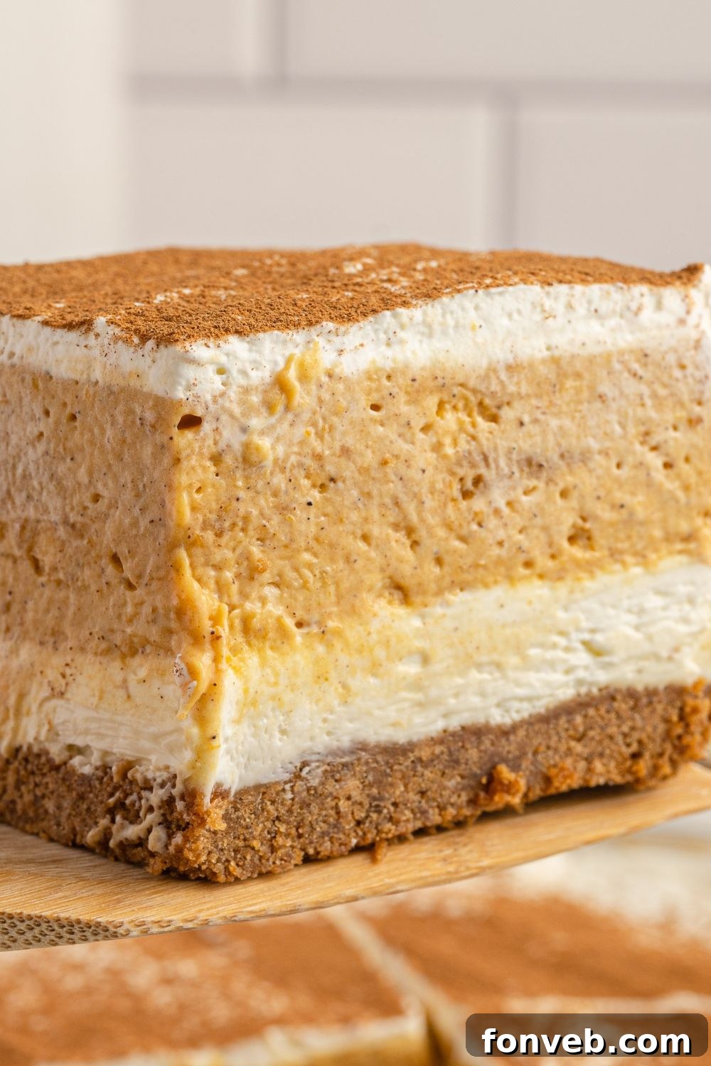A single slice of pumpkin delight dessert, neatly cut and displayed on a white plate.