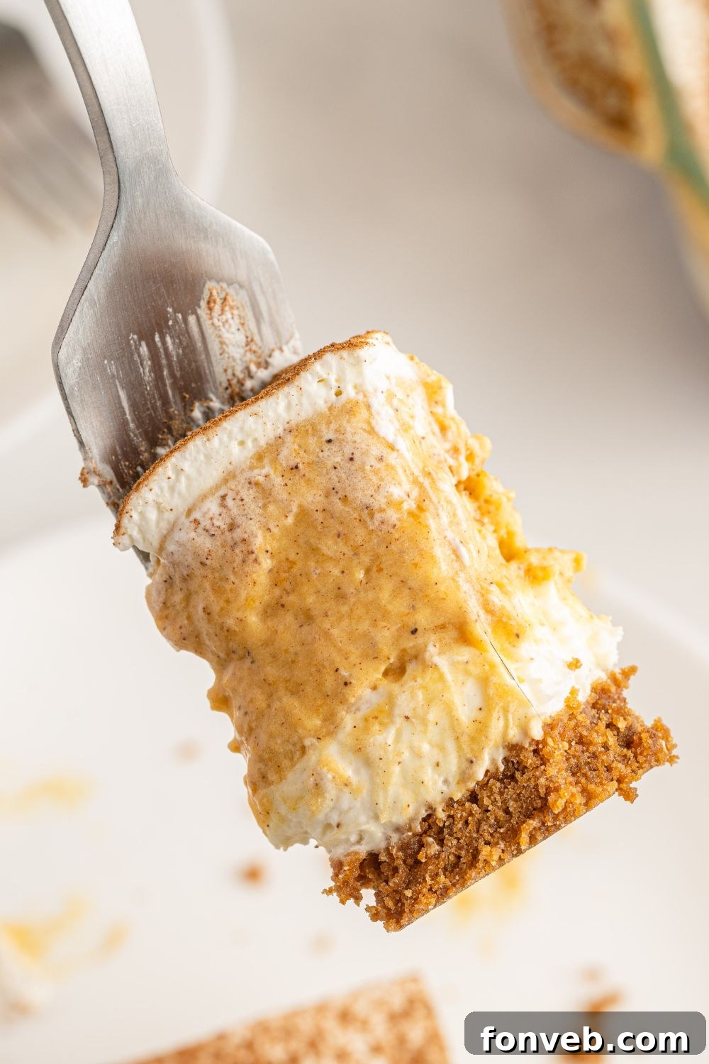 A fork with a perfect bite of Pumpkin Delight, showing the clean layers and ready to be eaten.