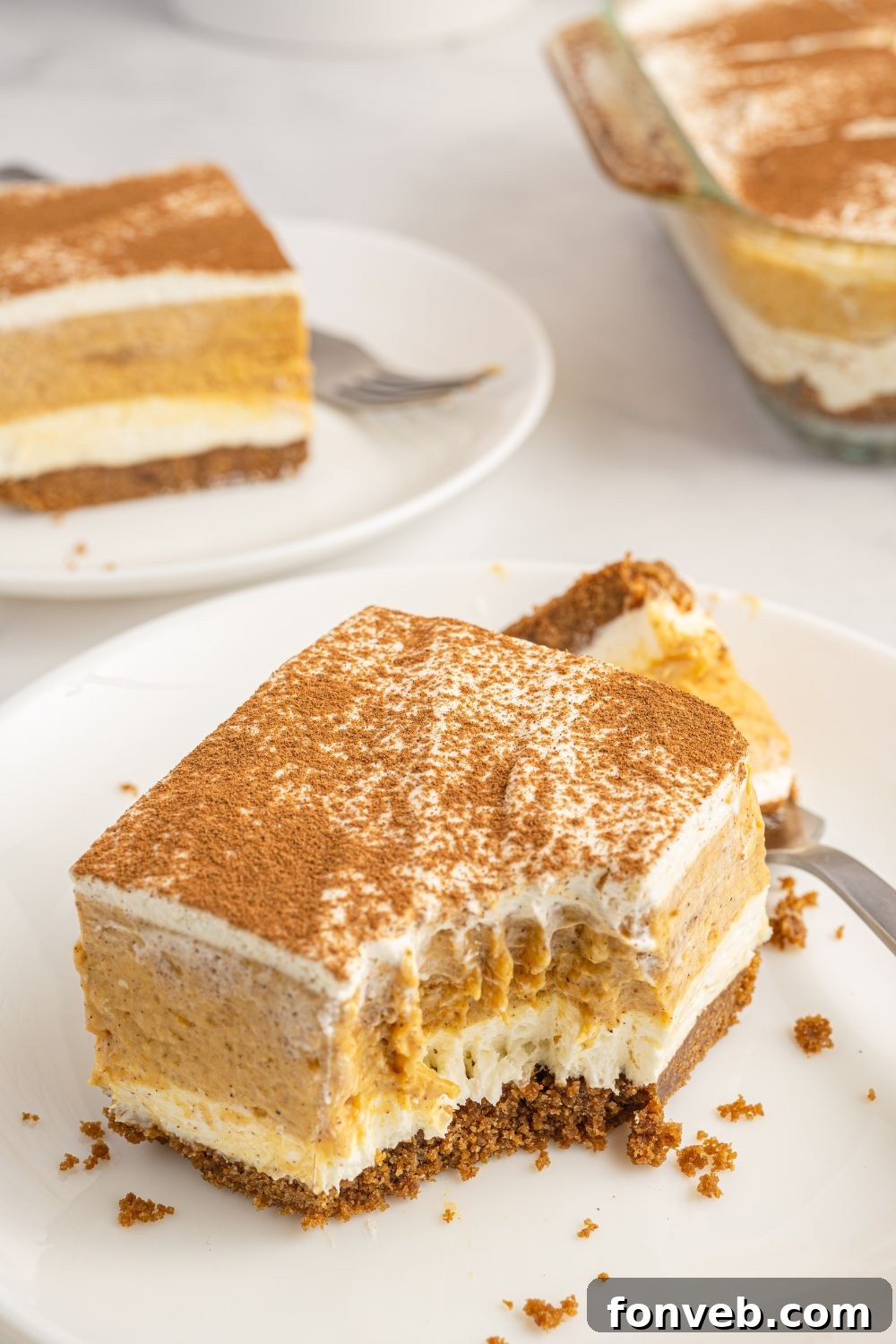 A slice of pumpkin pudding delight on a plate, with a fork mark showing where a bite has been taken.