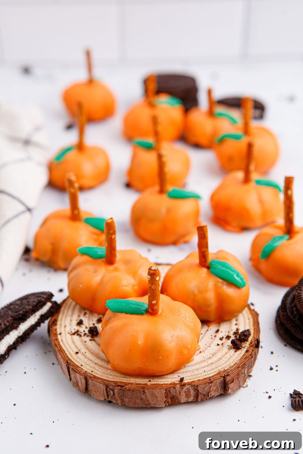 Pumpkin Spiced Oreo Truffles 2 Oreo balls on table and wooden tray with truffles on top of it