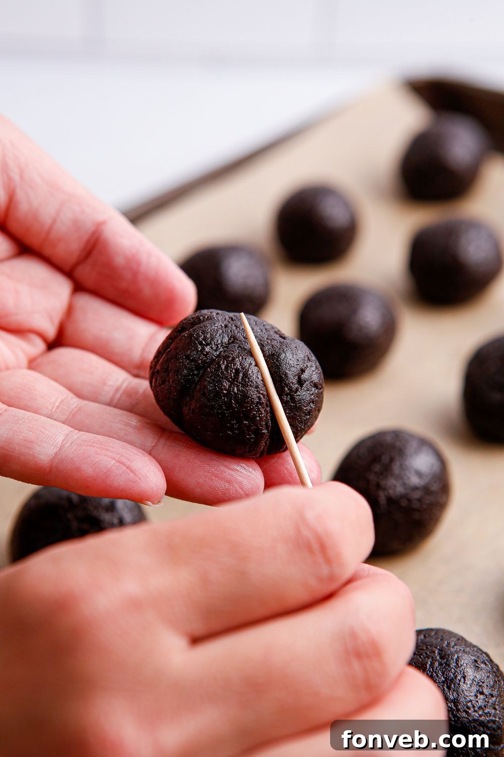 Pumpkin Spiced Oreo Truffles 10 toothpick pressing into an Oreo ball