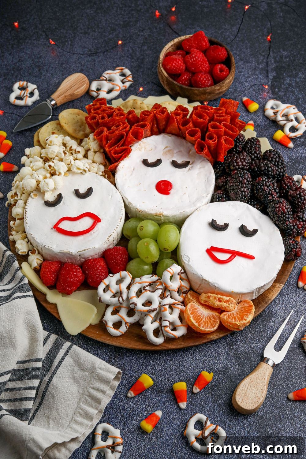 A close-up view of the Hocus Pocus snack board, featuring the intricately designed Sanderson Sisters faces made from Brie, surrounded by complementary Halloween treats.