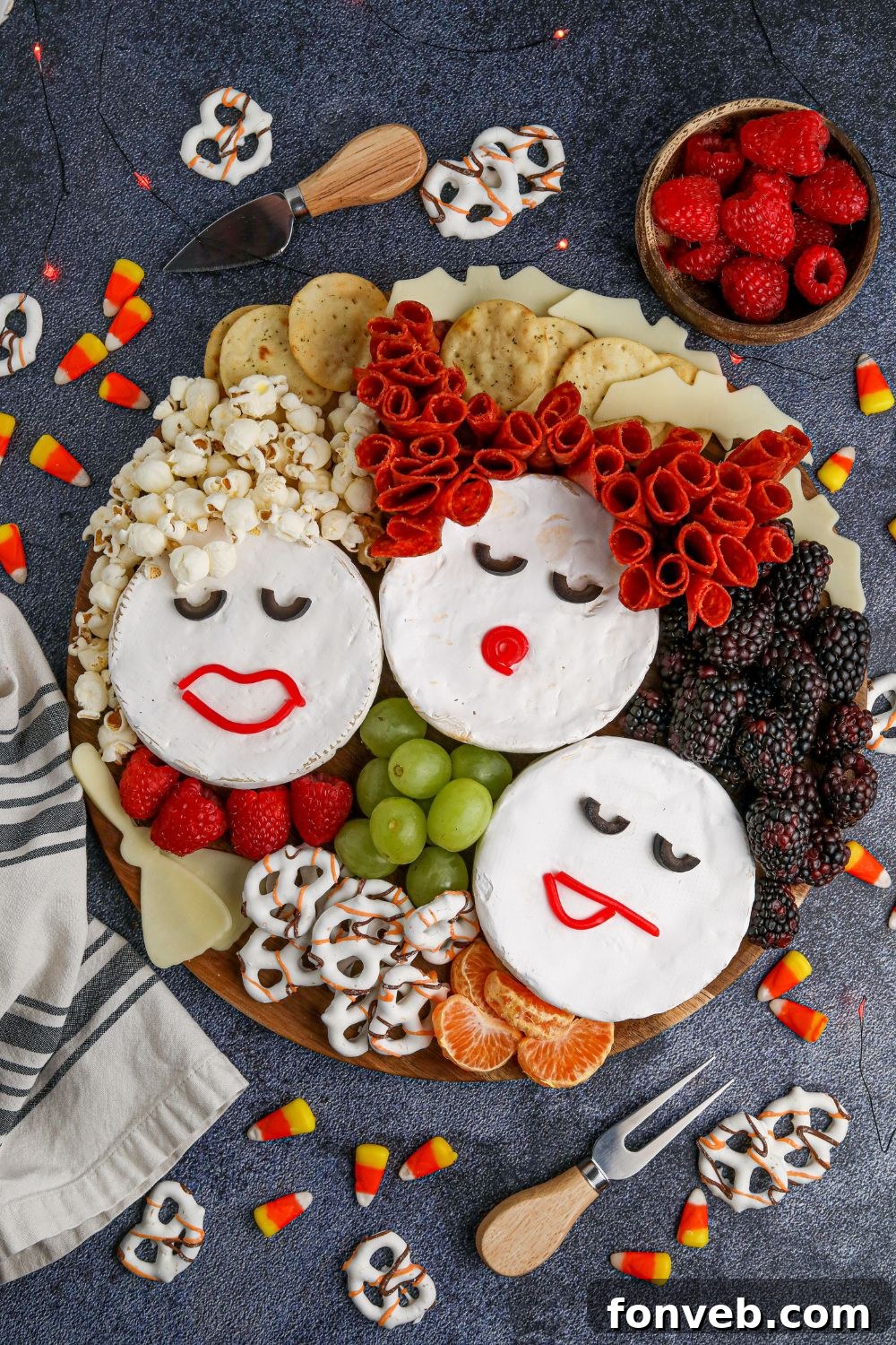 Close-up of the Sanderson Sisters charcuterie board arranged on a rustic wooden table, with various Halloween-themed snacks and decorative items subtly visible in the background.