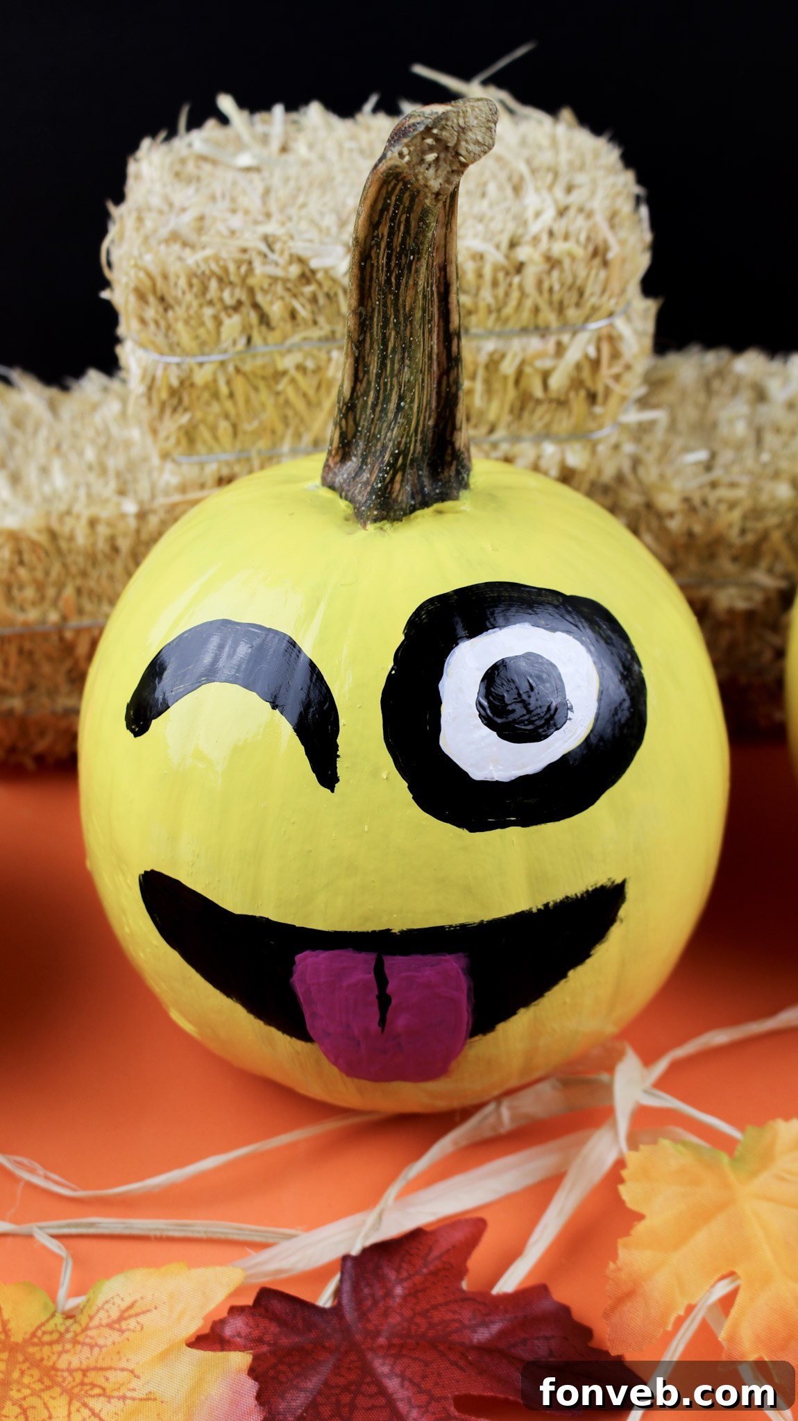 Pumpkins with Personality 12 A painted pumpkin depicting a silly emoji face with one winking eye and a tongue playfully sticking out, adding humor to fall decor.