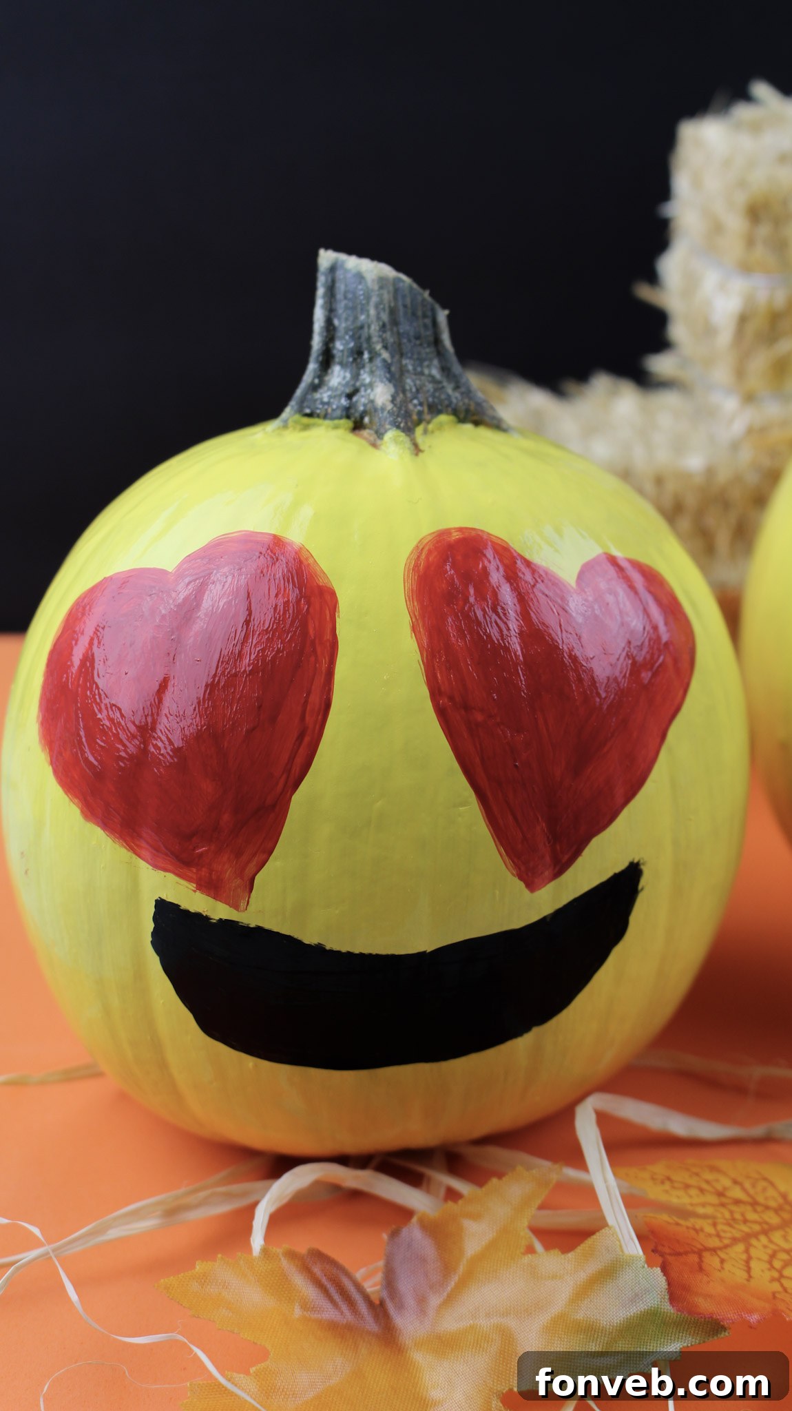 Pumpkins with Personality 13 A painted pumpkin with two large red heart eyes and a cheerful smile, embodying a loving and happy emoji expression.