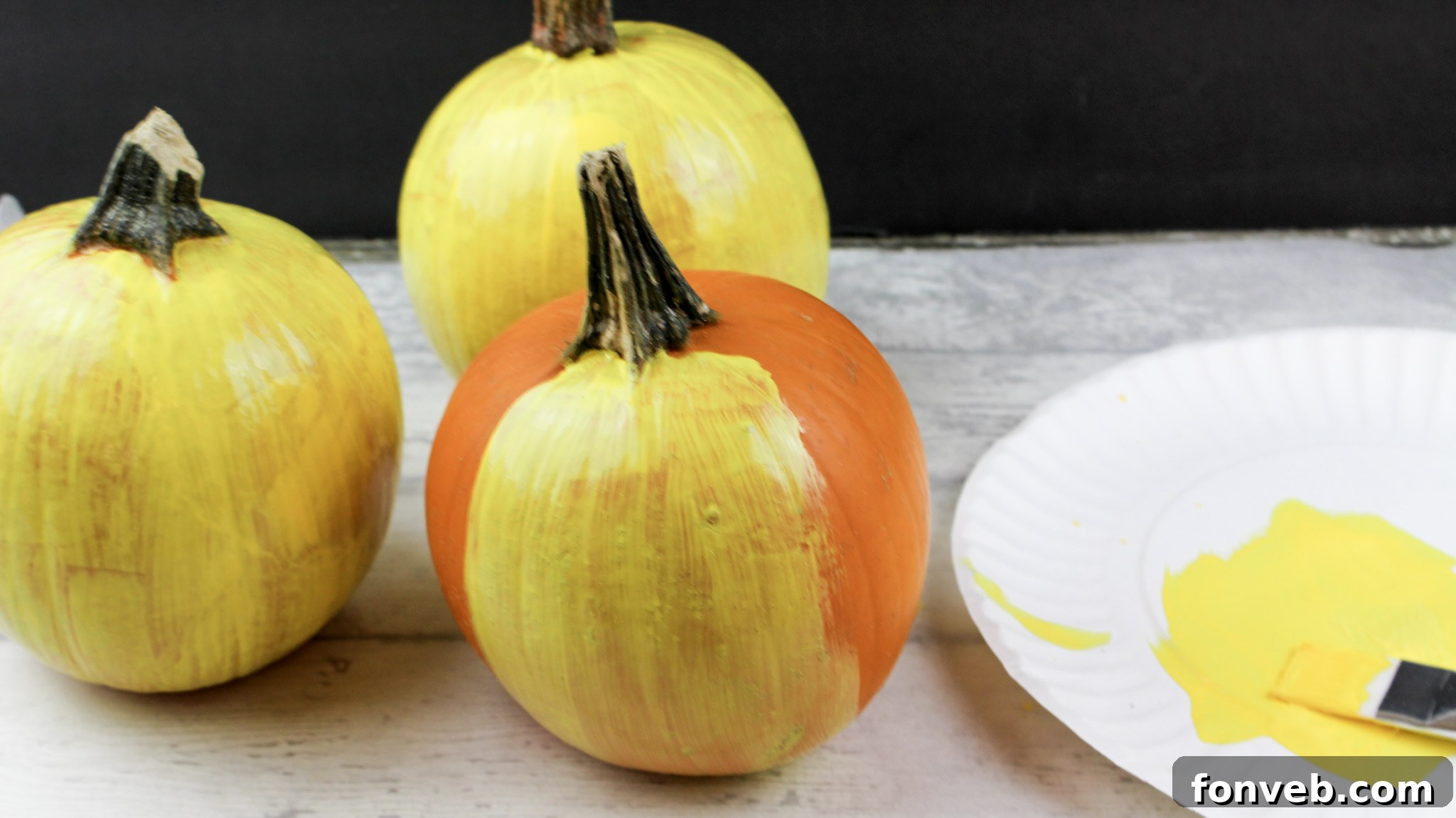 Pumpkins with Personality 4 Another perspective of the bright yellow painted pumpkin, highlighting its smooth, glossy finish as a base for designs.