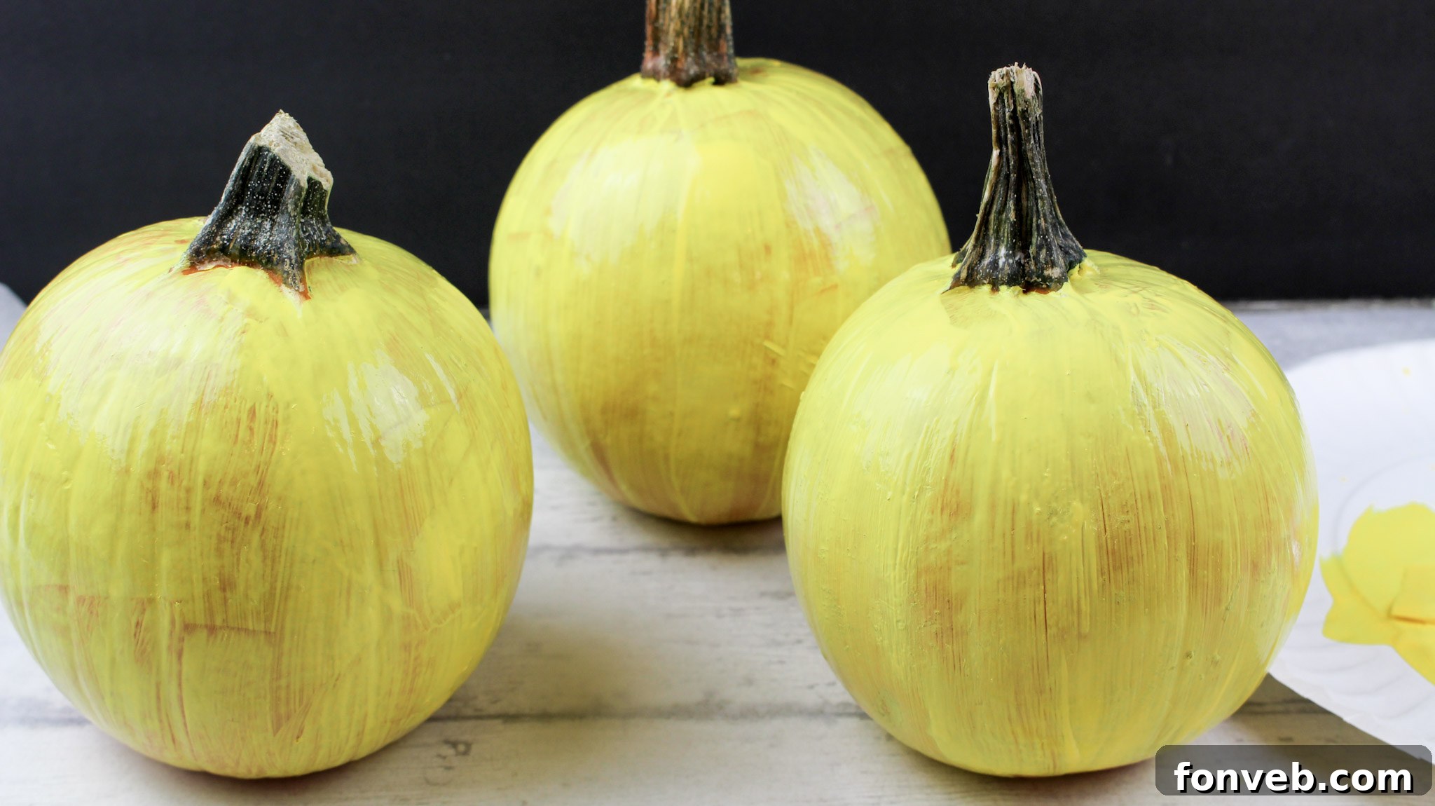 Pumpkins with Personality 5 Three small pumpkins meticulously painted in bright yellow, serving as a blank canvas for emoji faces.