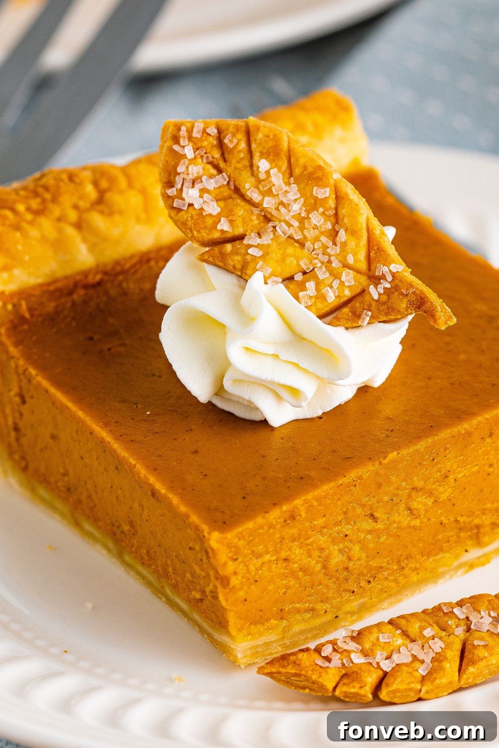 slice of pumpkin pie with cool whip and leaf crust on top