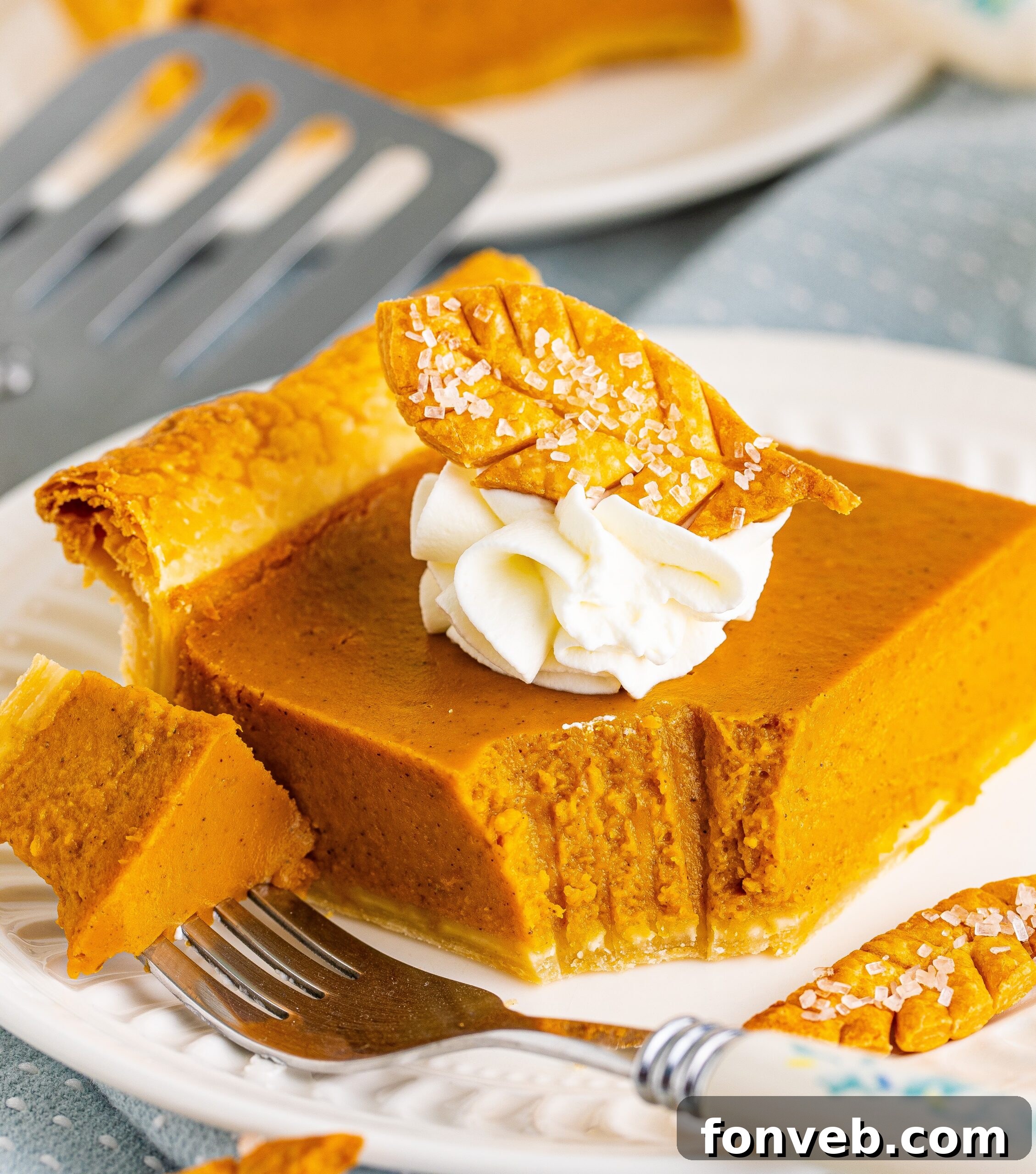 Pumpkin slab pie slice on a white plate with a bite removed on a fork