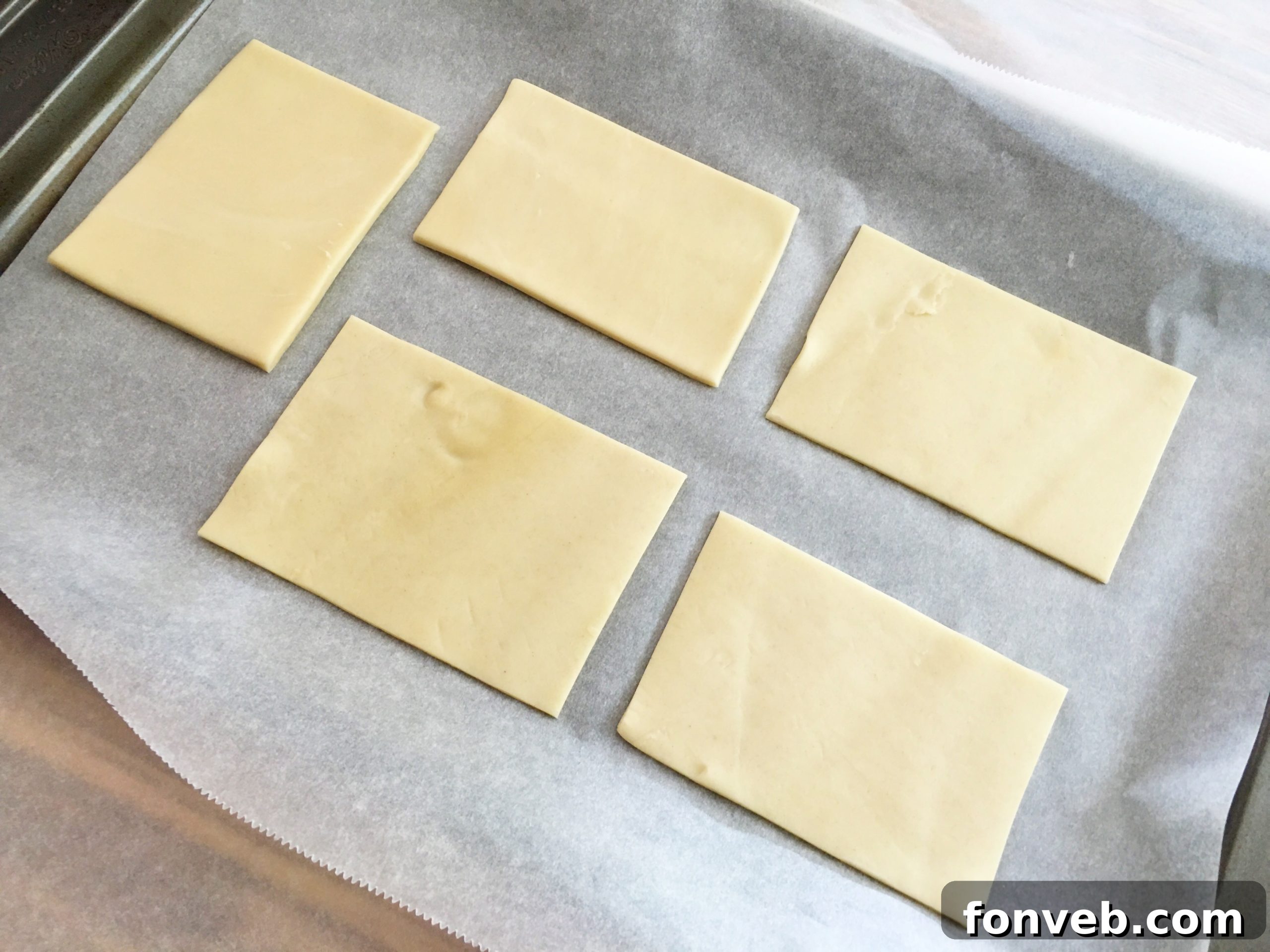 Using a cookie cutter to cut pie crust into small rectangles for mummy cookies