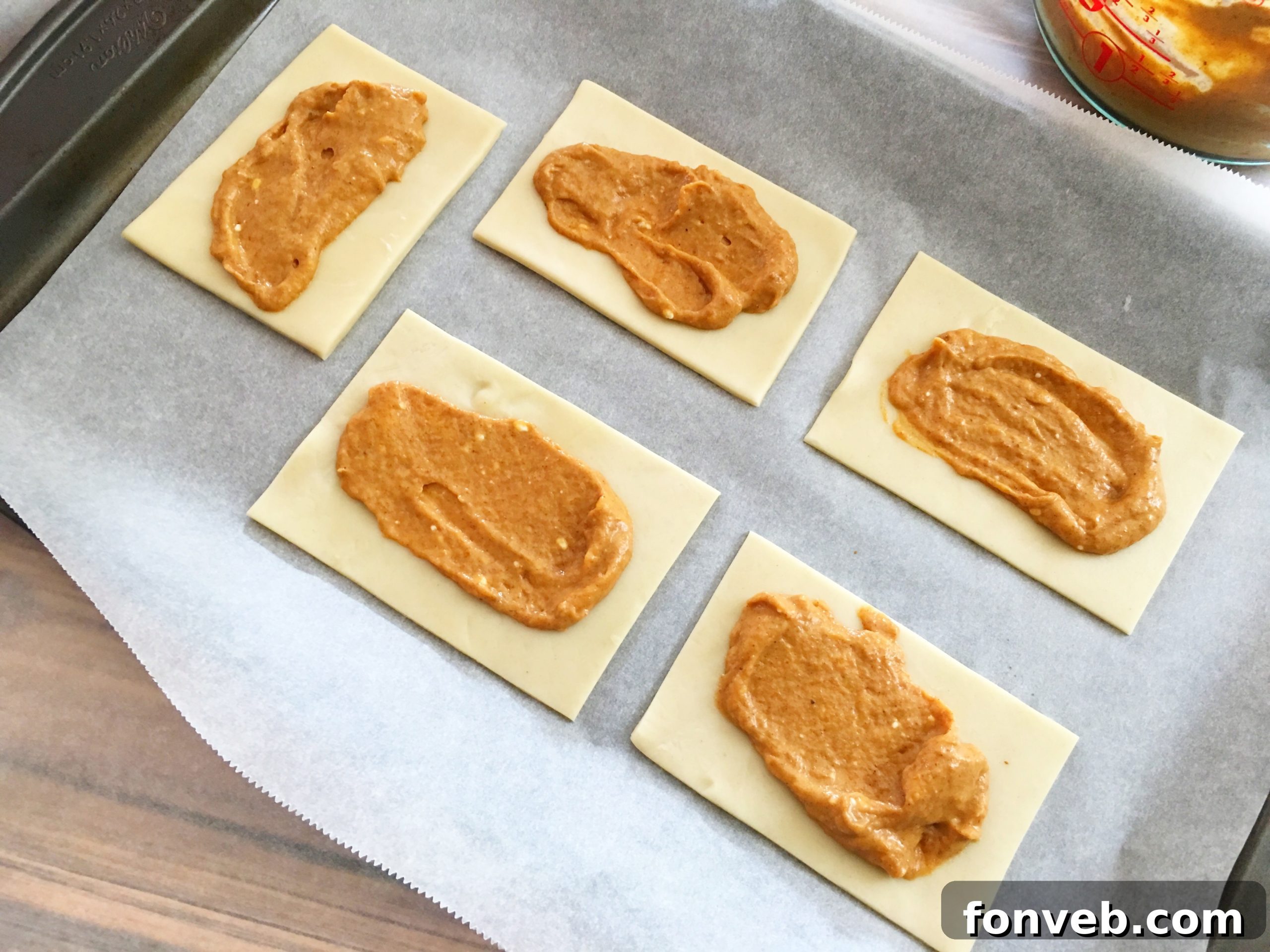 Spreading pumpkin pie filling onto the prepared pie crust rectangles