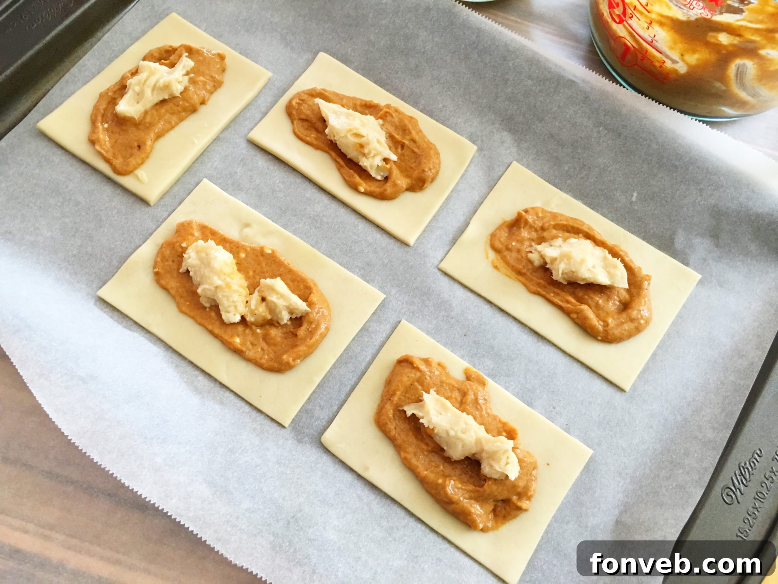 Layering the creamy cheesecake filling over the pumpkin pie filling