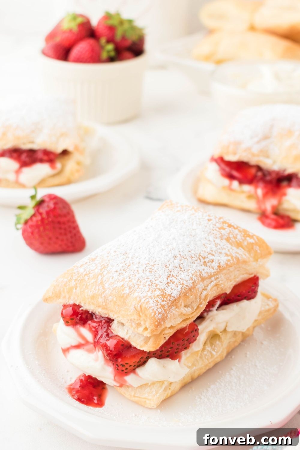 strawberry puff pastry desserts on plates around the table