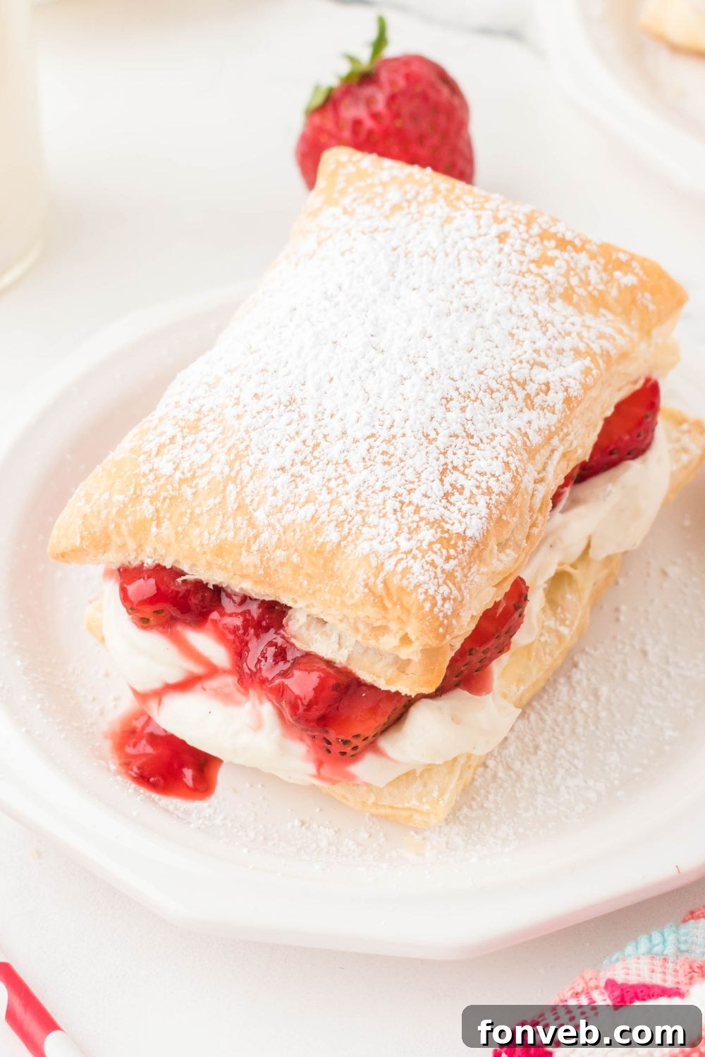 strawberry puffs pastry on plate with strawberry in the background