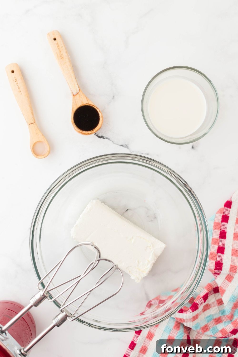 cream cheese in mixing bowl with mixer beaters in bowl