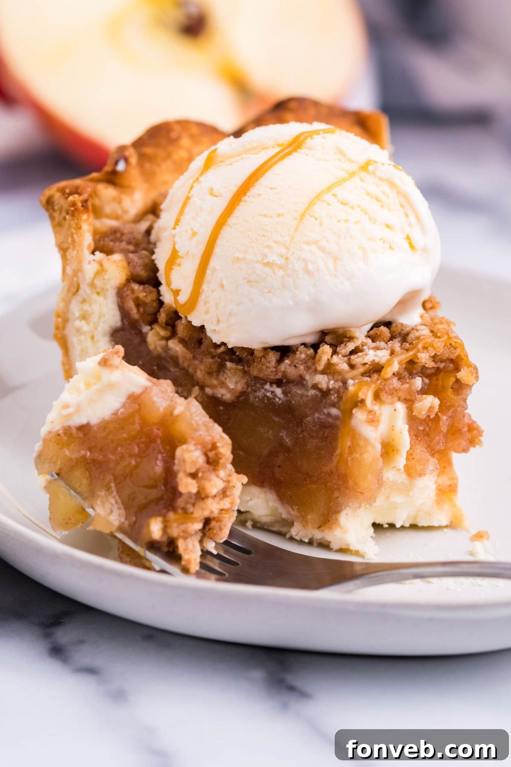 Spiced Apple Crumble Cheesecake Pie 4 bite taken out of piece of pie on table