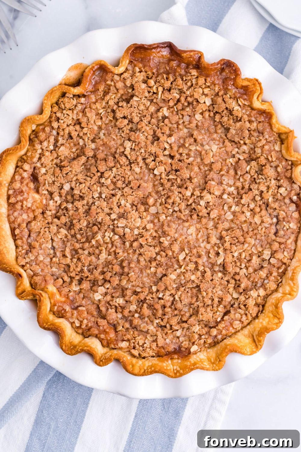 Spiced Apple Crumble Cheesecake Pie 5 apple crumble cheesecake in pan with towel under it