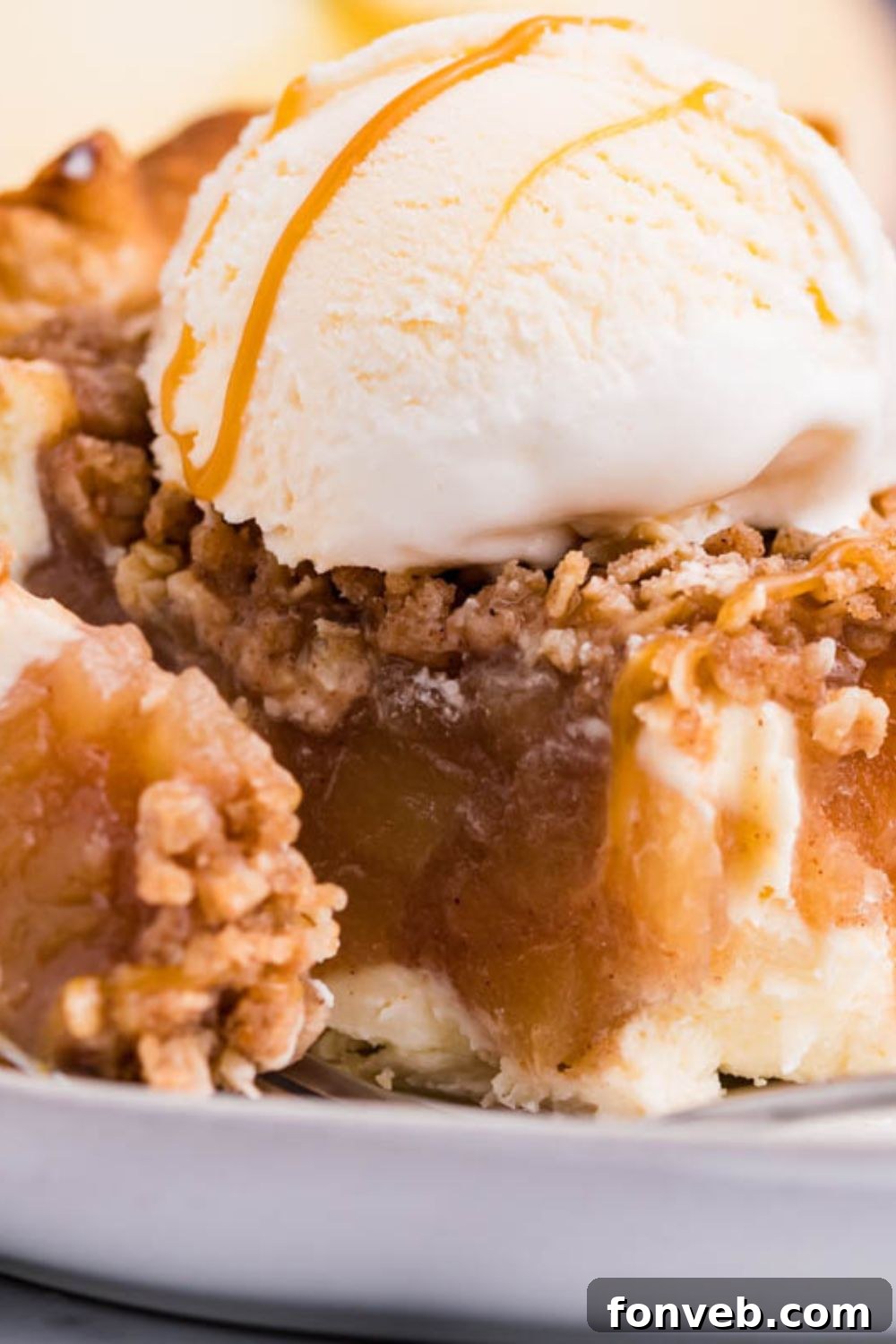 Spiced Apple Crumble Cheesecake Pie 6 Apple Crumble Cheesecake Pie slice on plate with a bite taken out of it