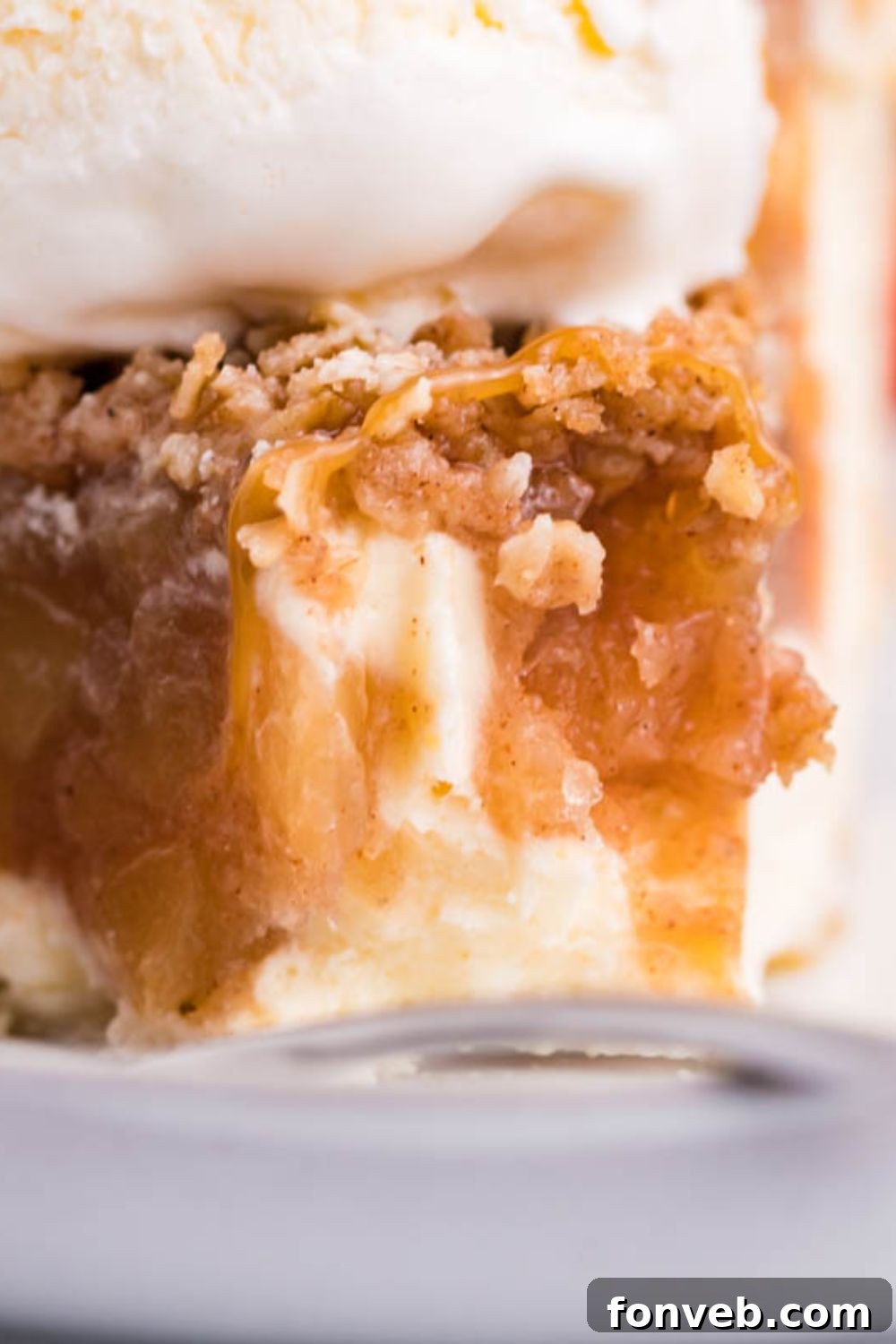 Spiced Apple Crumble Cheesecake Pie 8 apple crisp cheesecake on plate with bite taken out