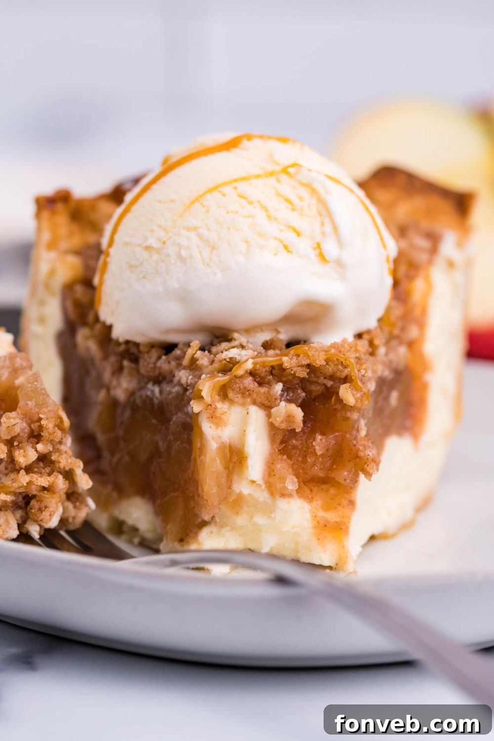 Spiced Apple Crumble Cheesecake Pie 10 apple cinnamon cheesecake with some bites taken out of it