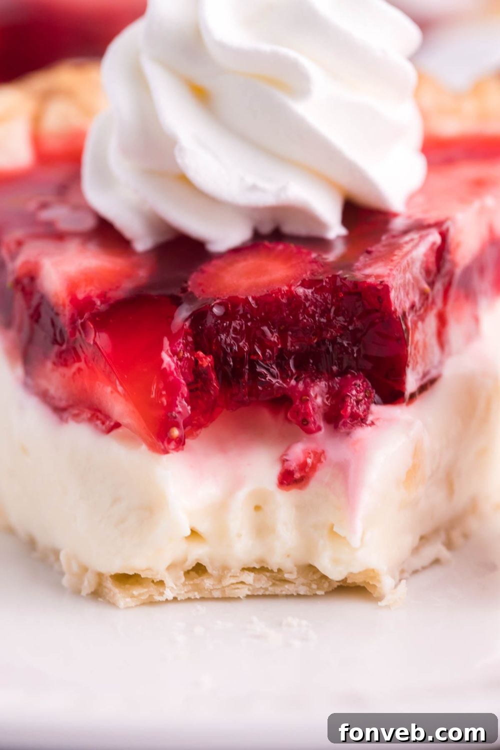 A close-up of a single slice of Strawberry Cream Cheese Pie on a white plate, with a fork gently taking a bite, showing the rich layers and textures.