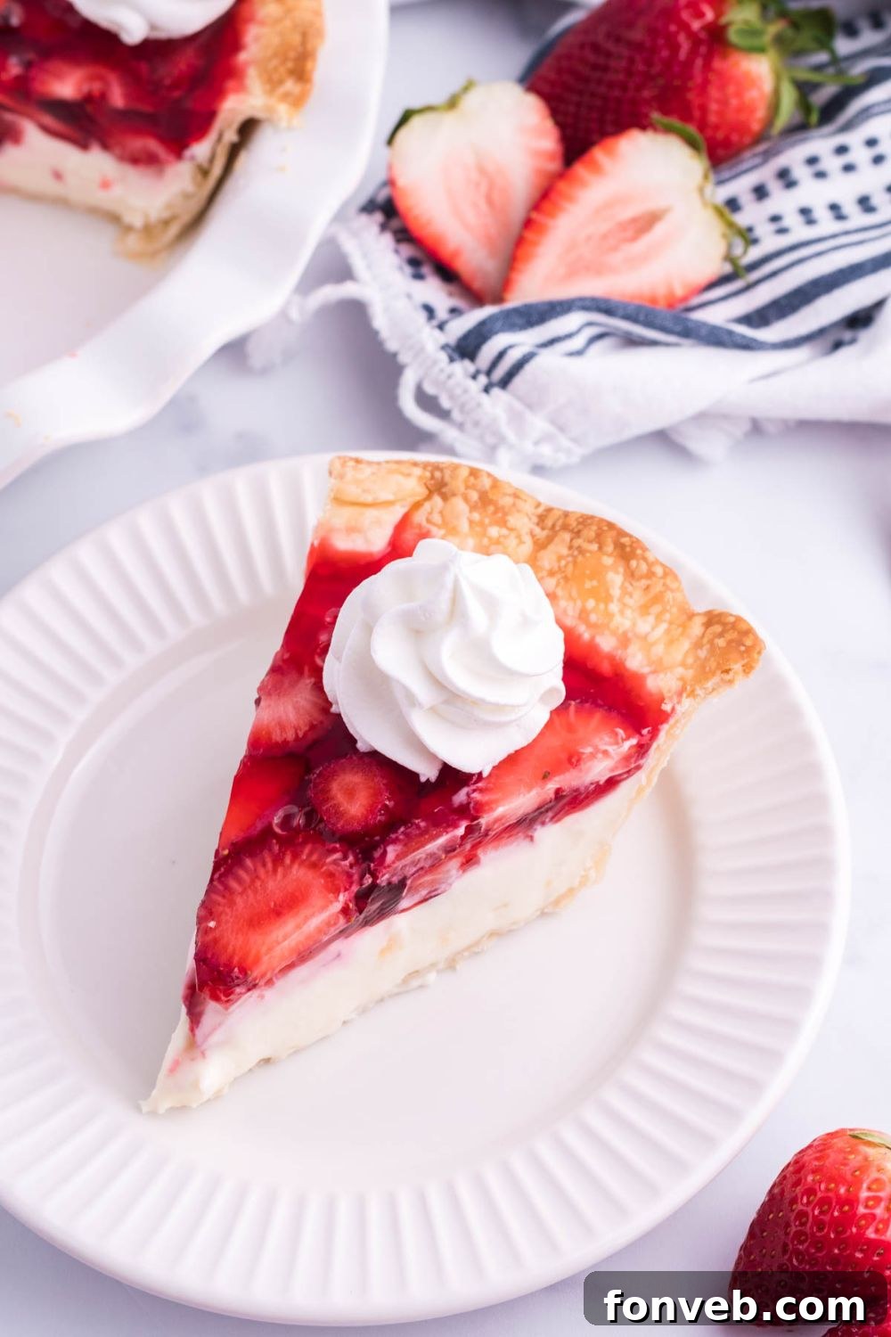 A whole Strawberry Cream Cheese Pie, perfectly sliced and arranged on a white serving plate, highlighting its smooth and appealing texture.