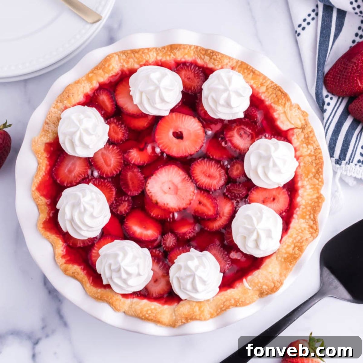 Overhead shot of a full Strawberry Cream Cheese Pie in a white pie plate, showcasing the glossy strawberry topping and vibrant red fruit, a perfect centerpiece for any dessert table.