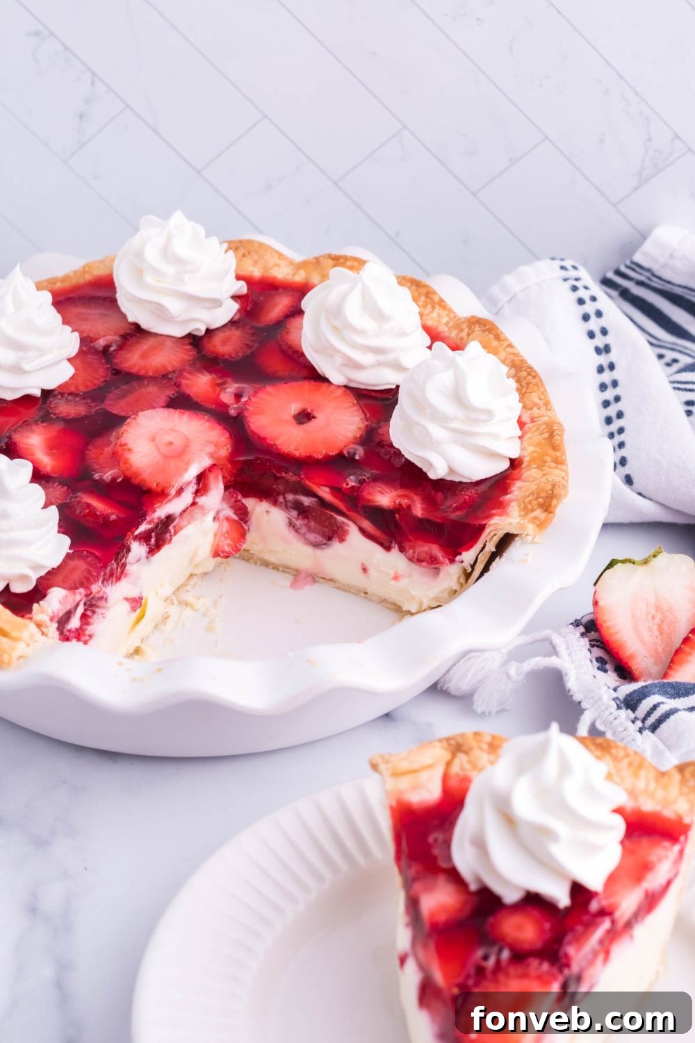 A complete Strawberry Cream Cheese Pie in its pan, with a single slice elegantly placed on a separate white plate, ready to be enjoyed.