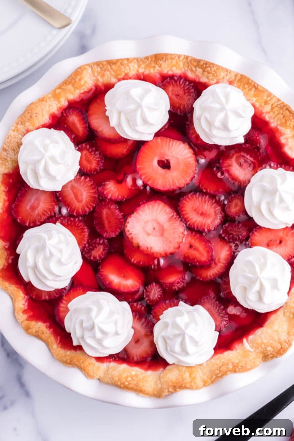 An inviting overhead shot of a creamy strawberry pie still in its pan, showcasing the rich texture and vibrant colors of the fruit and filling.