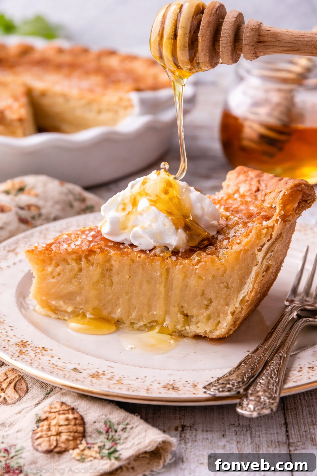 Golden Sweetheart 2 A beautifully baked Honey Pie slice on an elegant white plate, with a golden drizzle of honey gracefully falling onto its surface.