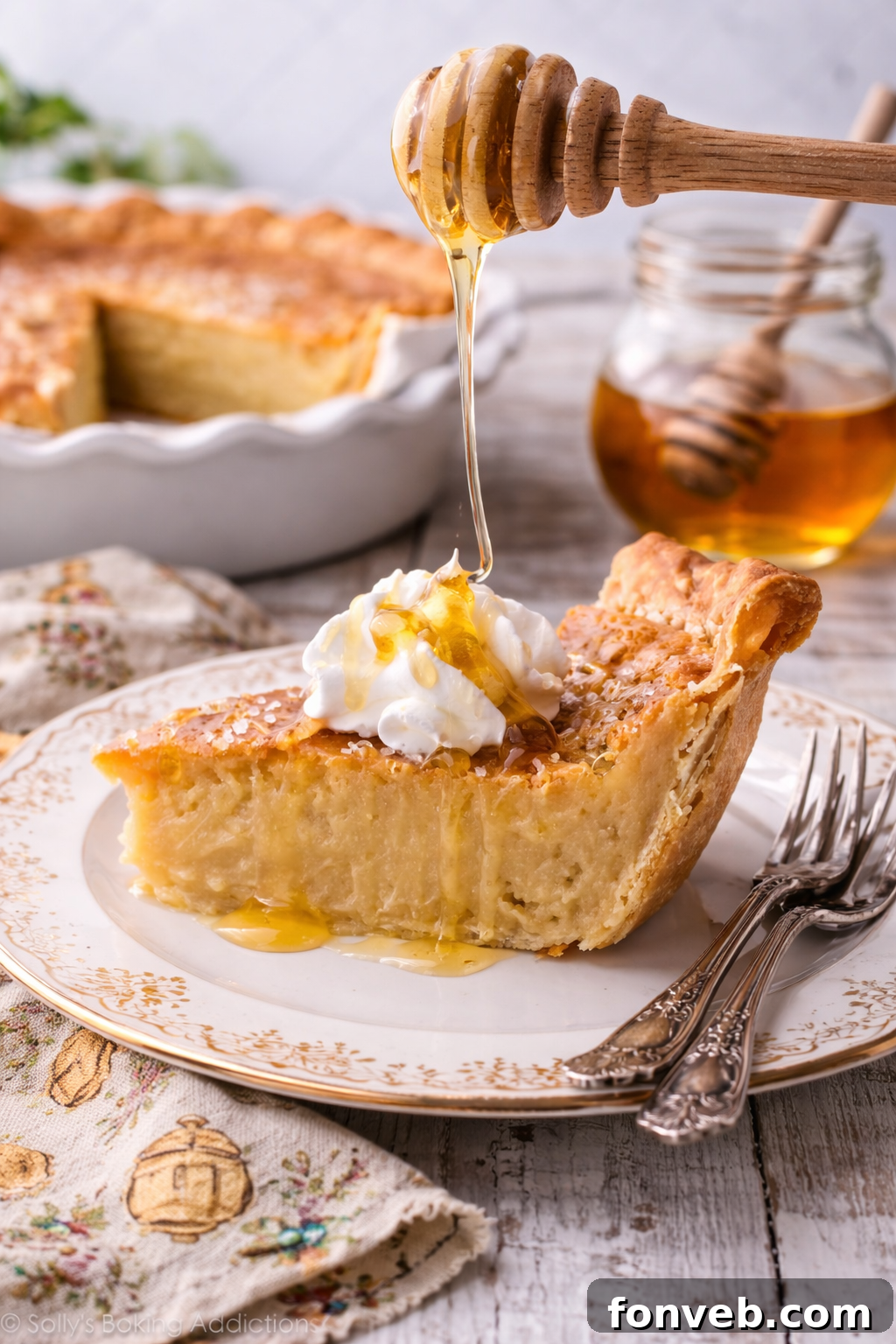 Golden Sweetheart 12 An elegantly styled honey pie slice rests on a beautiful white plate, perfectly positioned as golden honey cascades down onto its surface.
