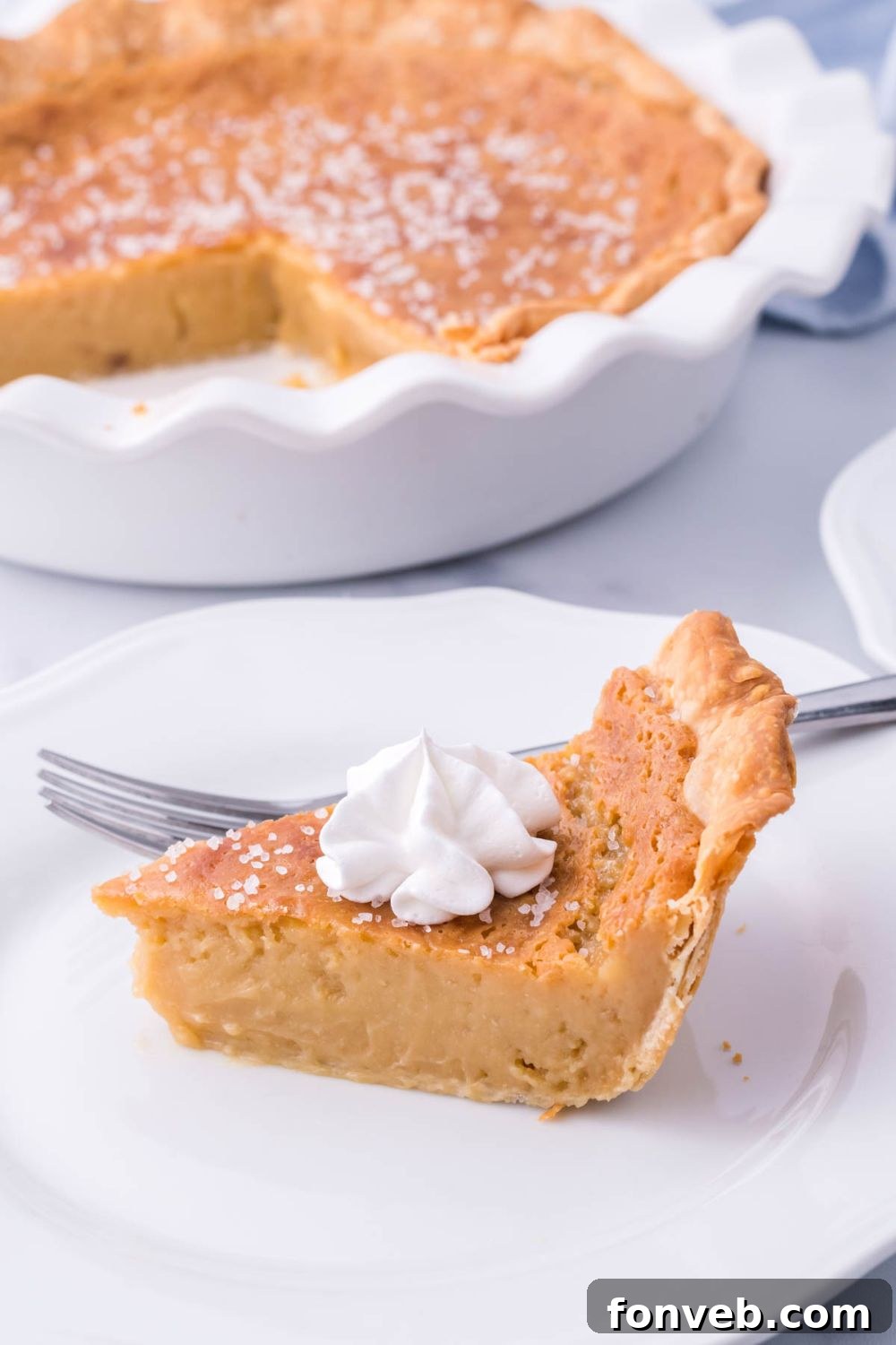 Golden Sweetheart 10 A pristine slice of honey pie on a plate, beautifully presented with the full pie blurred in the background, ready for serving.