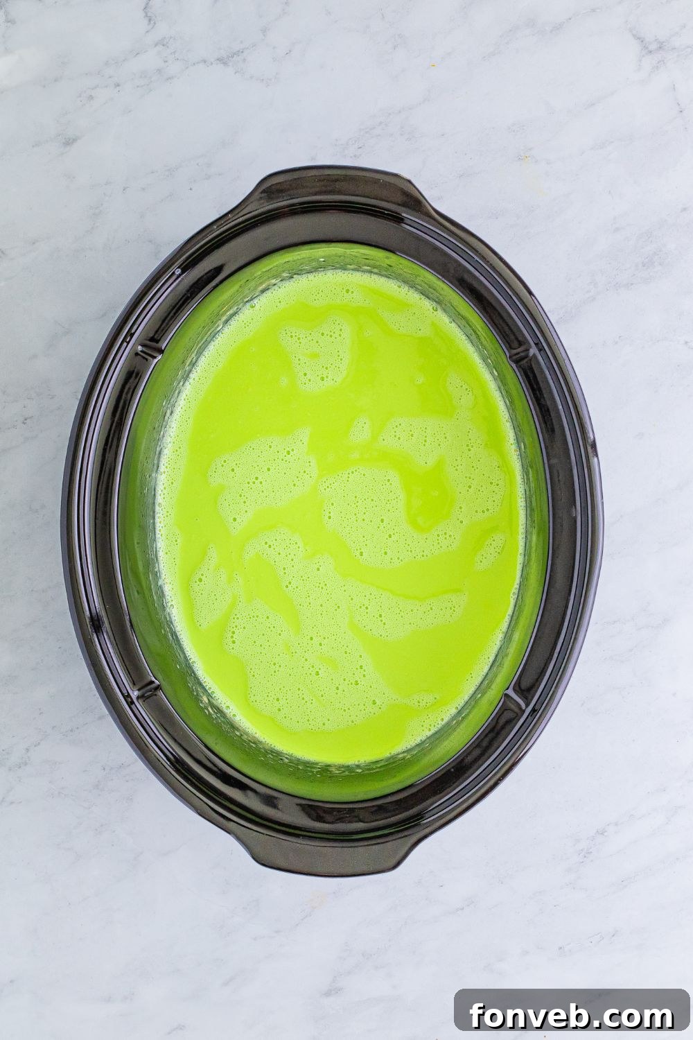 Grinch Hot Chocolate warming in a slow cooker on a table