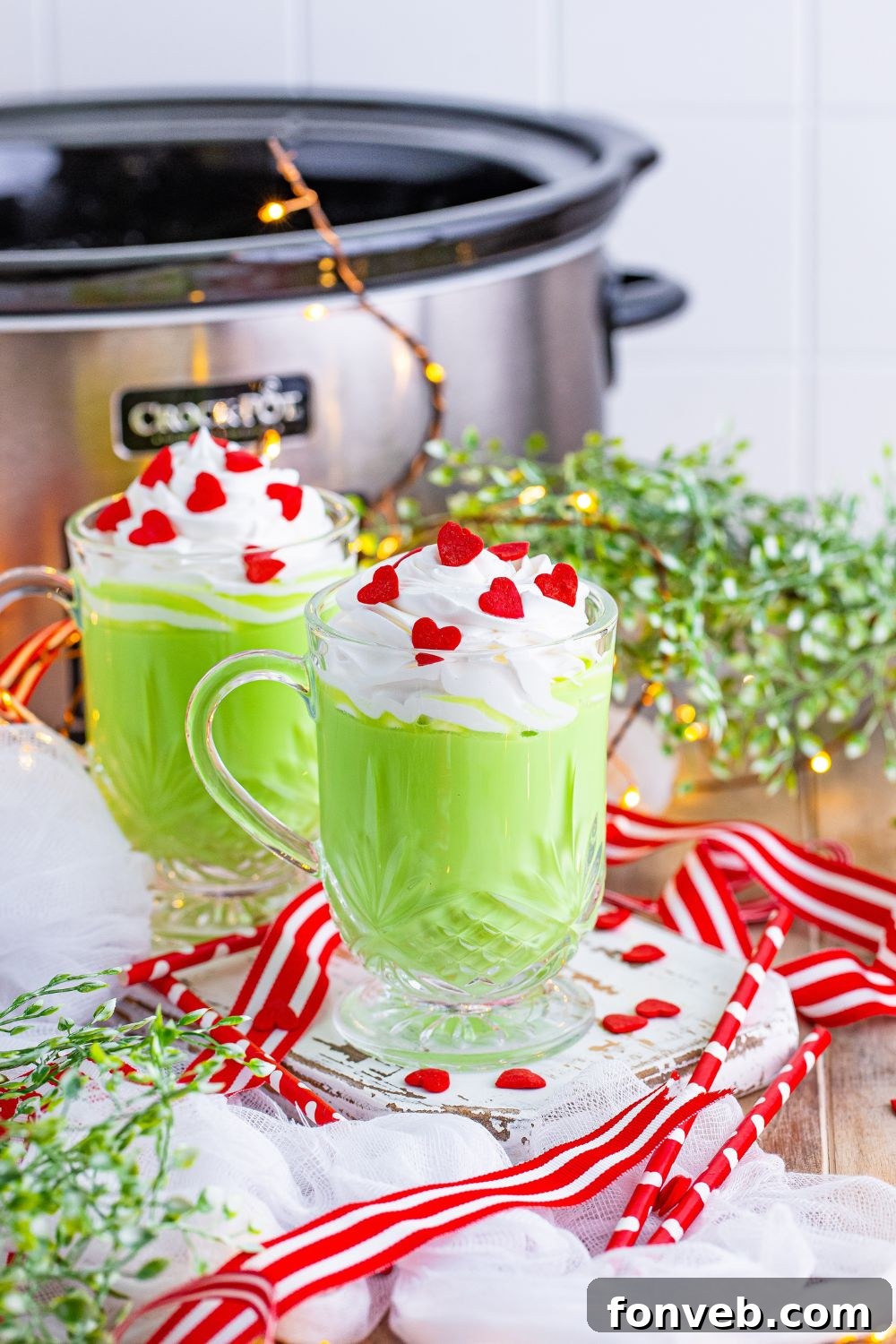 The Grinch green colored hot chocolate on a table with a slow cooker in the background