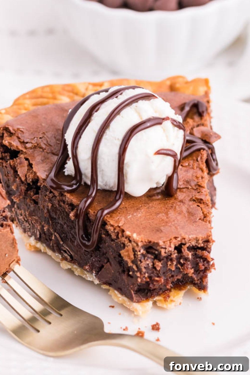 Fudgy Brownie Pie Perfection 19 A slice of chocolate pie on a plate, topped with a scoop of vanilla ice cream.
