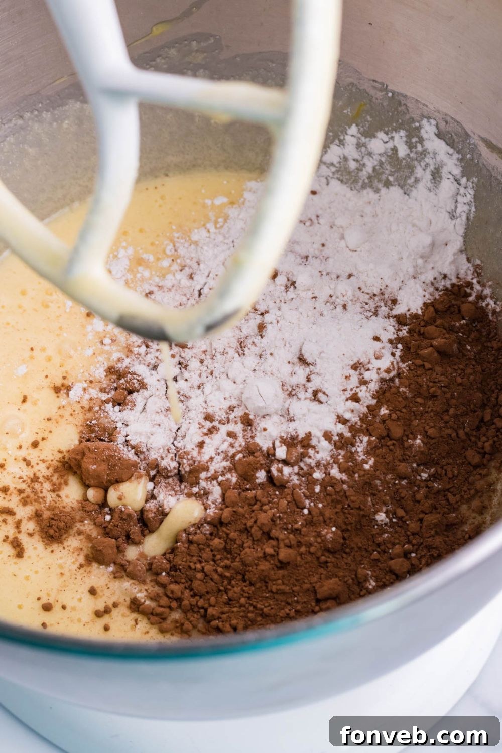 Fudgy Brownie Pie Perfection 7 Stand mixer with brownie batter ingredients in the bowl, being mixed.
