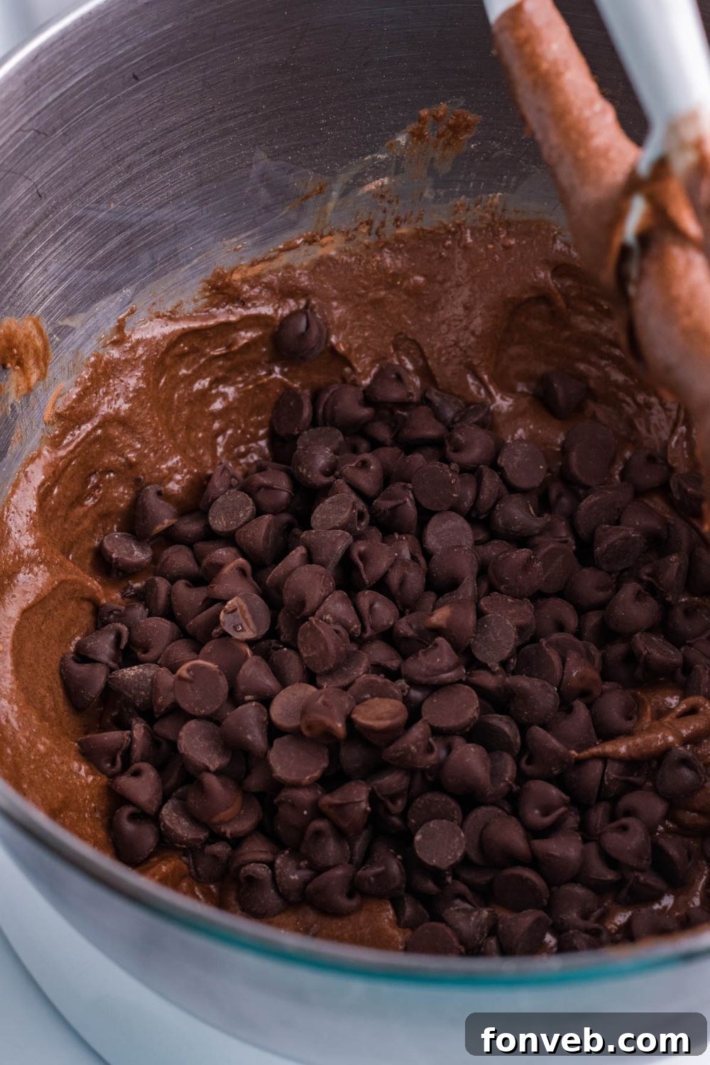 Fudgy Brownie Pie Perfection 8 Chocolate chips scattered on top of brownie pie batter in a mixing bowl.