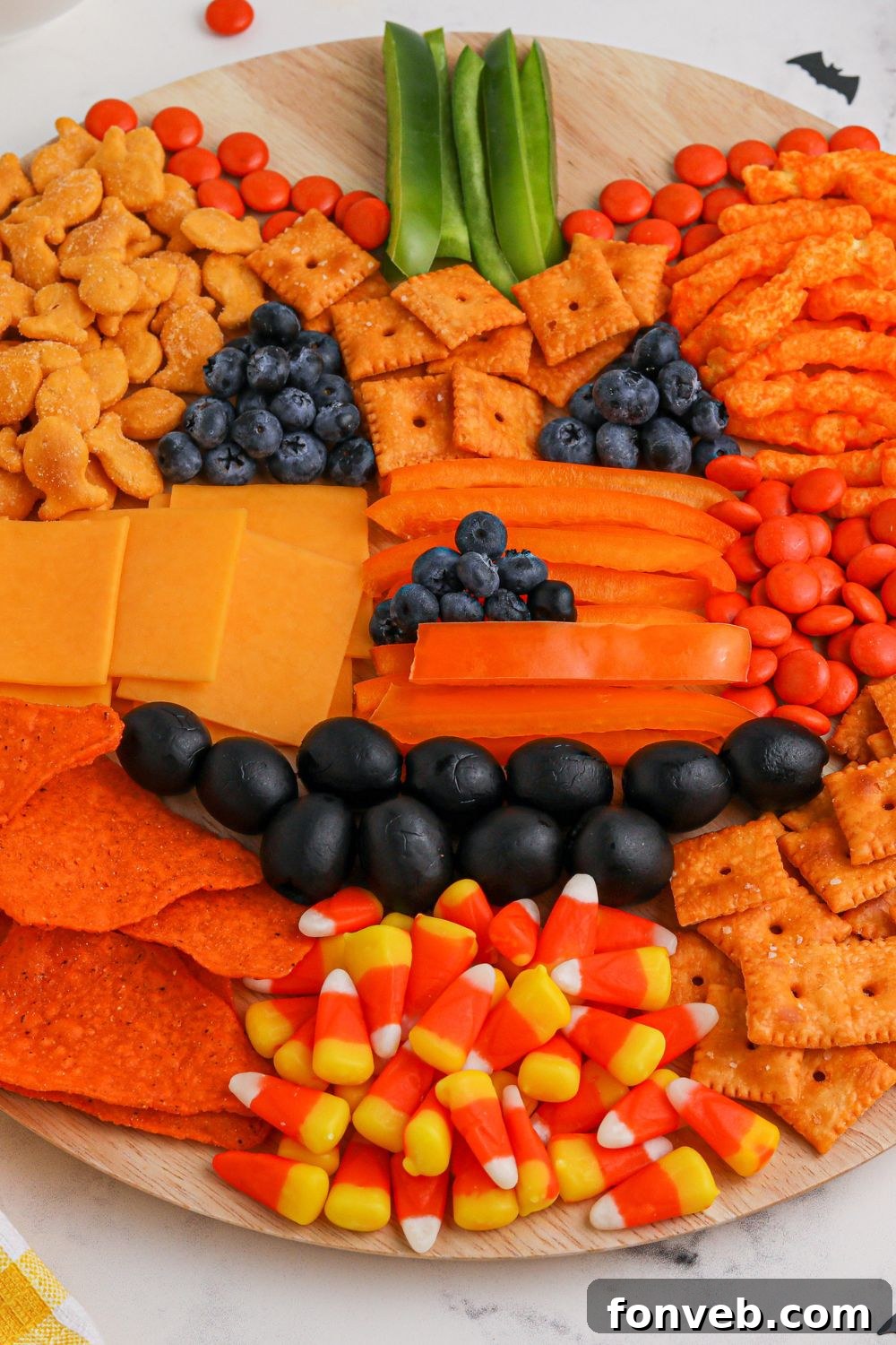 Overhead view of a pumpkin snack board in progress, showcasing the circular layout.