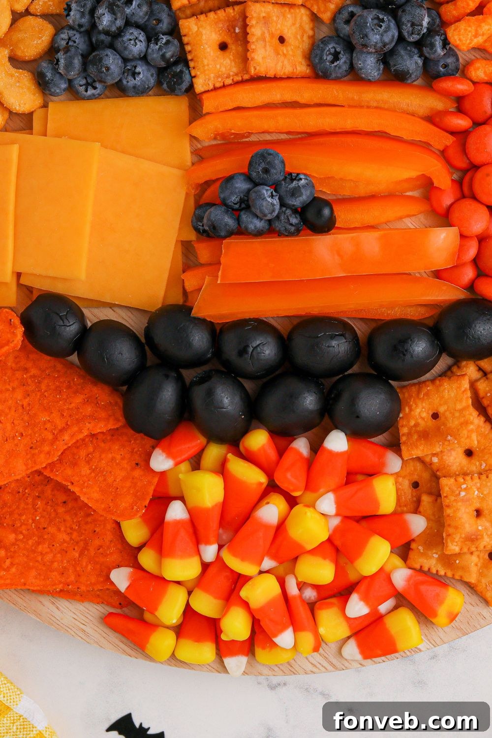 A beautifully presented Pumpkin Charcuterie Board with a rich variety of snacks.