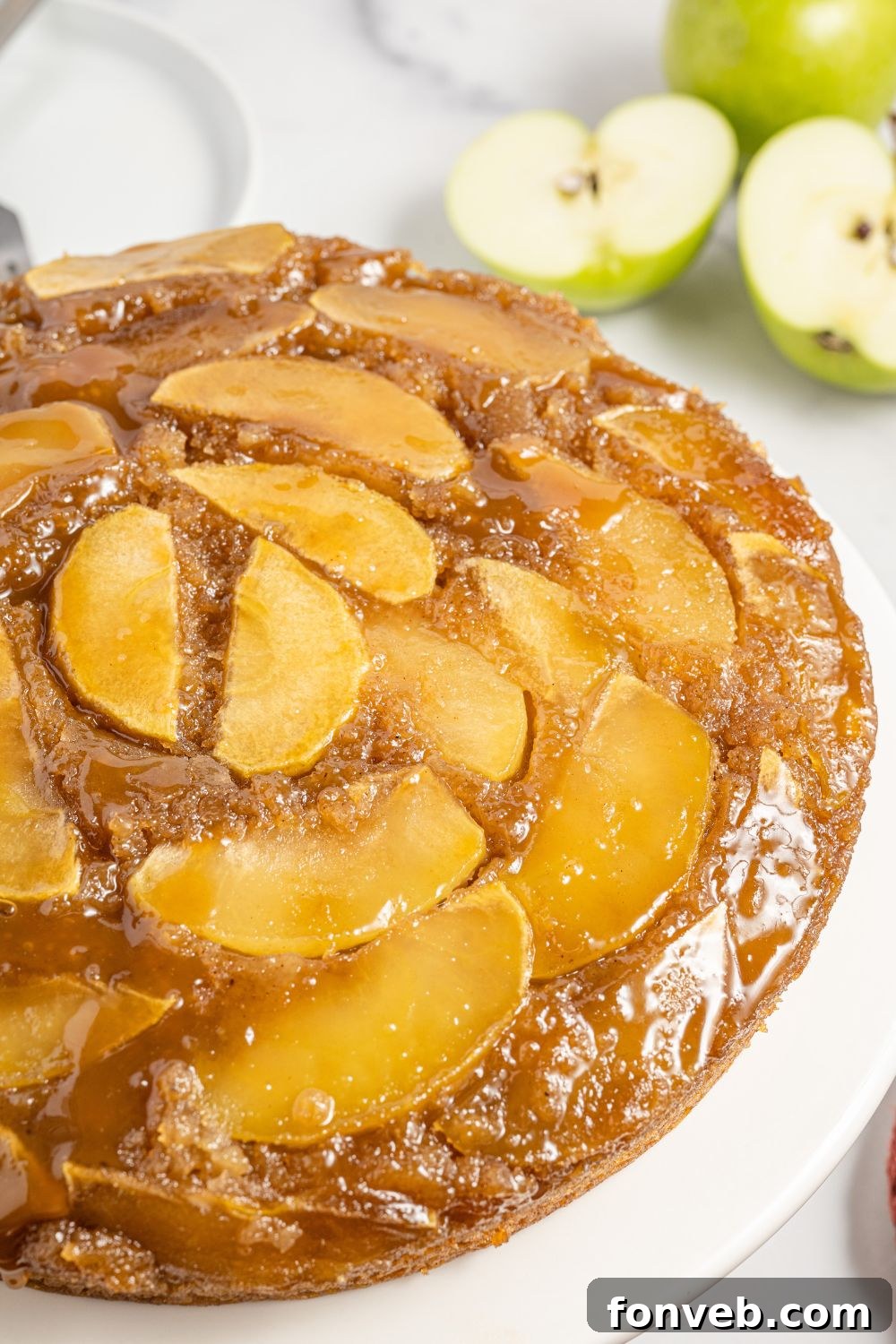 Caramelized Apple Bliss Cake 2 side view of an apple upside down cake on a platter, showcasing its golden crust and fruit layer