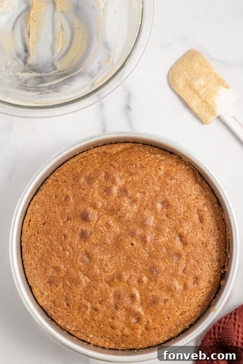 Caramelized Apple Bliss Cake 11 A freshly baked apple upside down cake still in its pan on a marble counter, cooling
