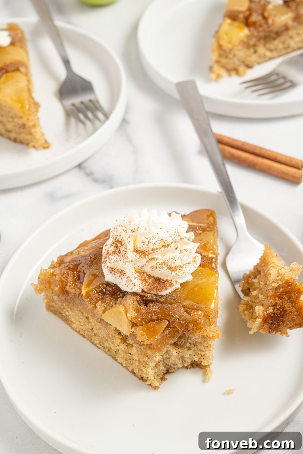 Caramelized Apple Bliss Cake 16 A slice of the apple upside down cake on a white plate with a fork, ready to be enjoyed