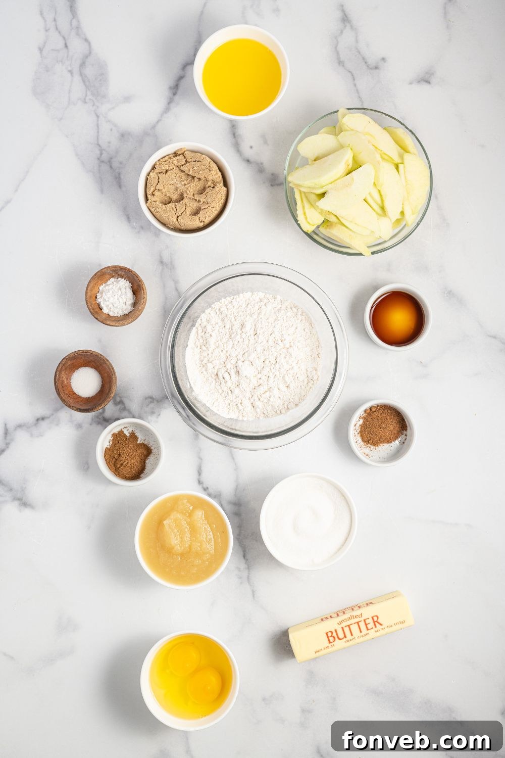 Caramelized Apple Bliss Cake 5 Overhead shot of various ingredients for an apple upside down cake neatly arranged in bowls on a kitchen counter