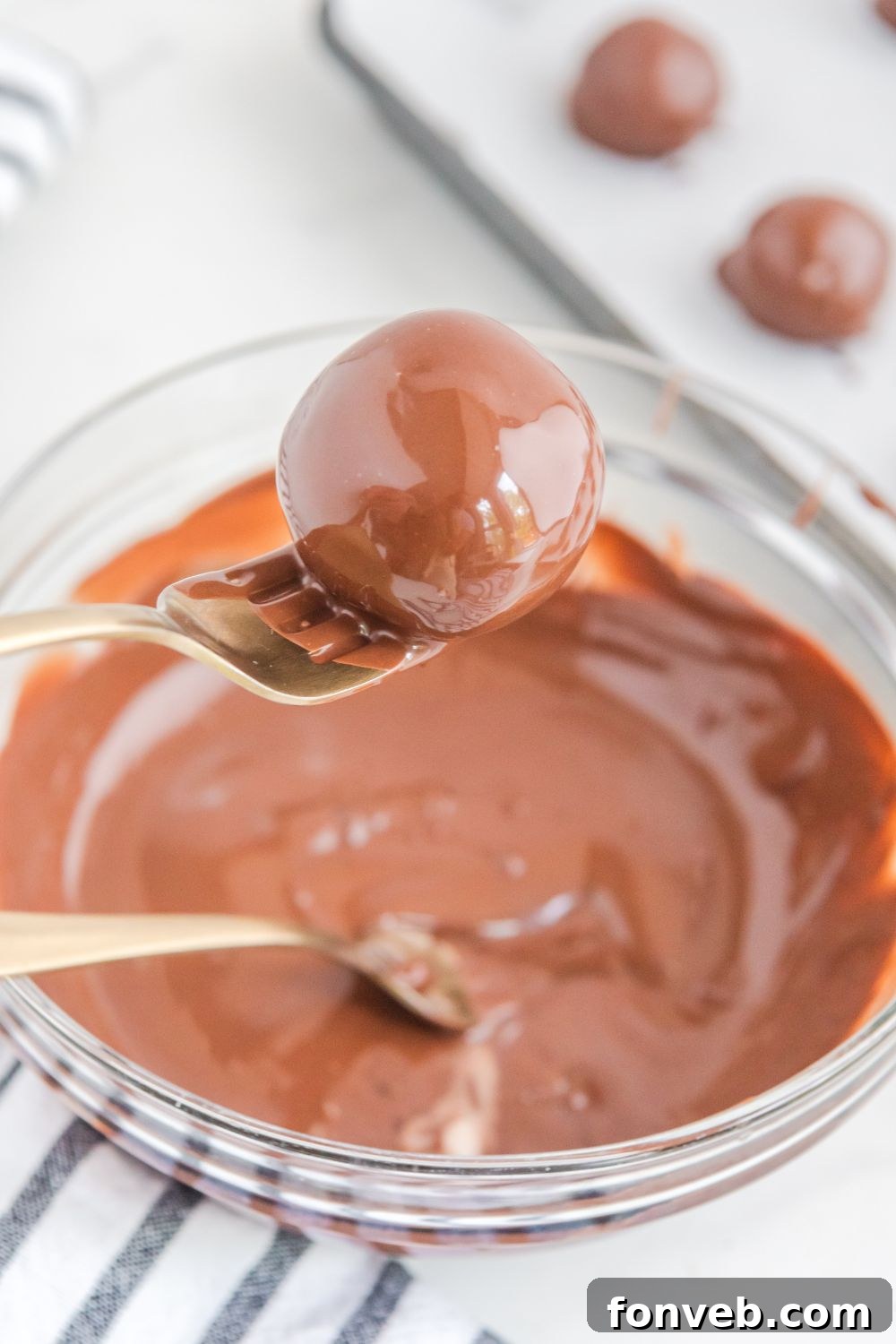 A freshly dipped brownie bomb covered in smooth melted chocolate